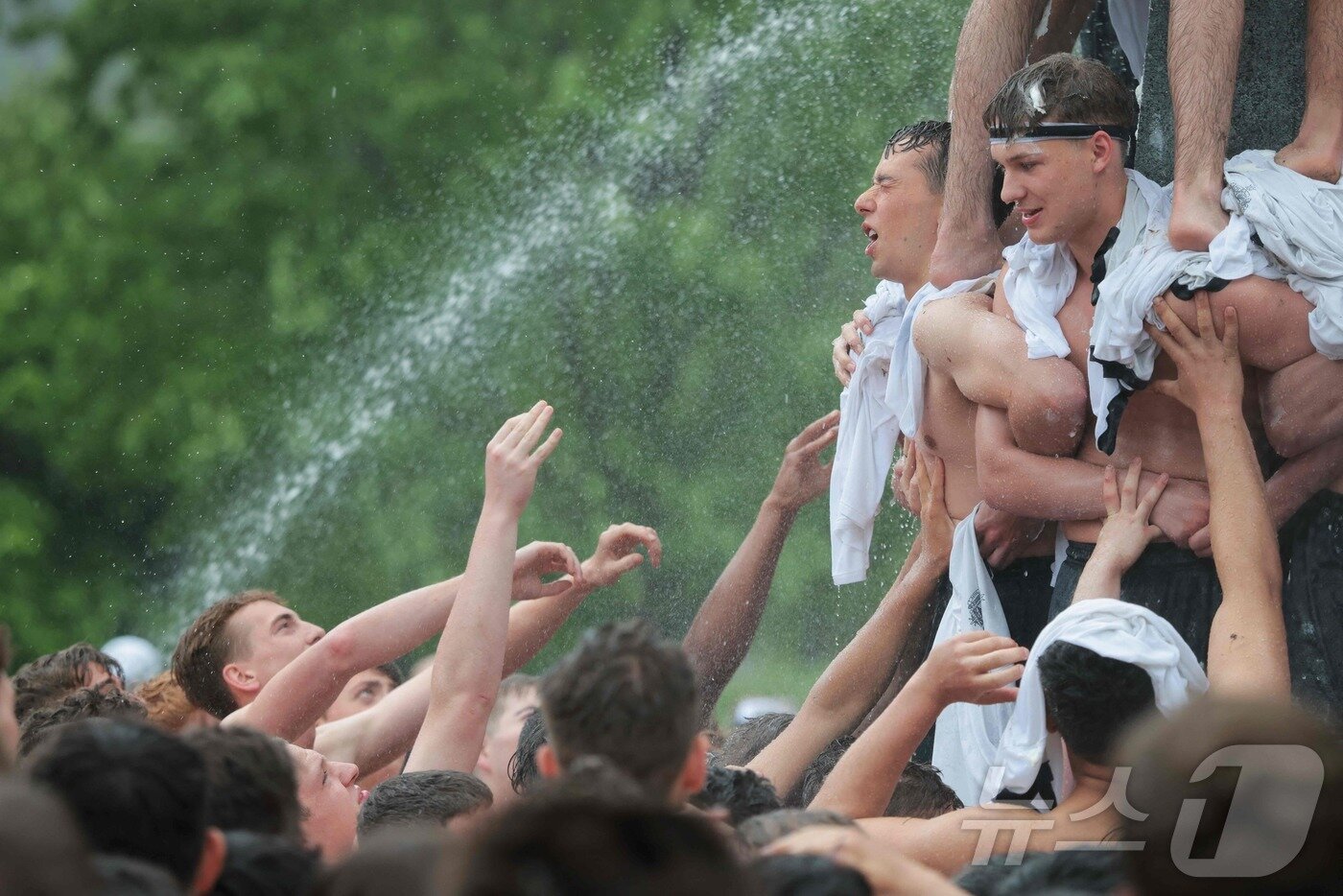 본문 이미지 - 미국 해군사관학교에서 사관생도들이 14일(현지시간) 미국 메릴랜드 주 아나폴리스 미 해군 사관학교에서 '딕시 컵'을 떨어뜨리기 위해 인간 피라미드를 만들어 헌던 기념물 꼭대기에 오르고 있다.  ⓒ AFP=뉴스1