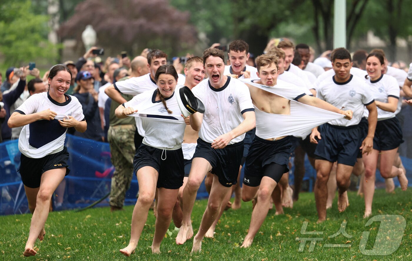 본문 이미지 - 미국 해군사관학교에서 사관생도들이 14일(현지시간) 미국 메릴랜드 주 아나폴리스 미 해군 사관학교에서 헌던 탑을 오르기 위해 달려가고 있다. ⓒ 로이터=뉴스1