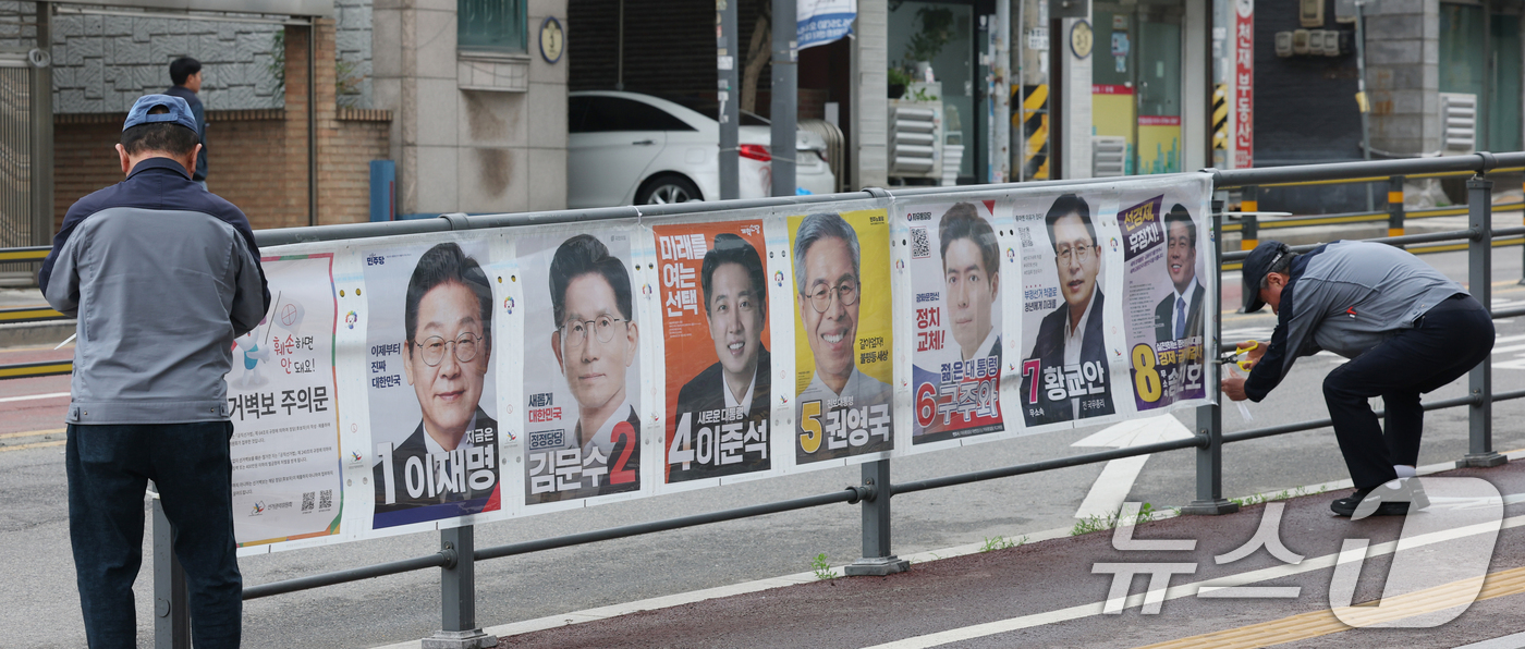 (수원=뉴스1) 김영운 기자 = 15일 경기 수원시 권선구의 한 거리에서 관계자들이 제21대 대통령선거 후보자들 선거 벽보를 부착하고 있다. 2025.5.15/뉴스1