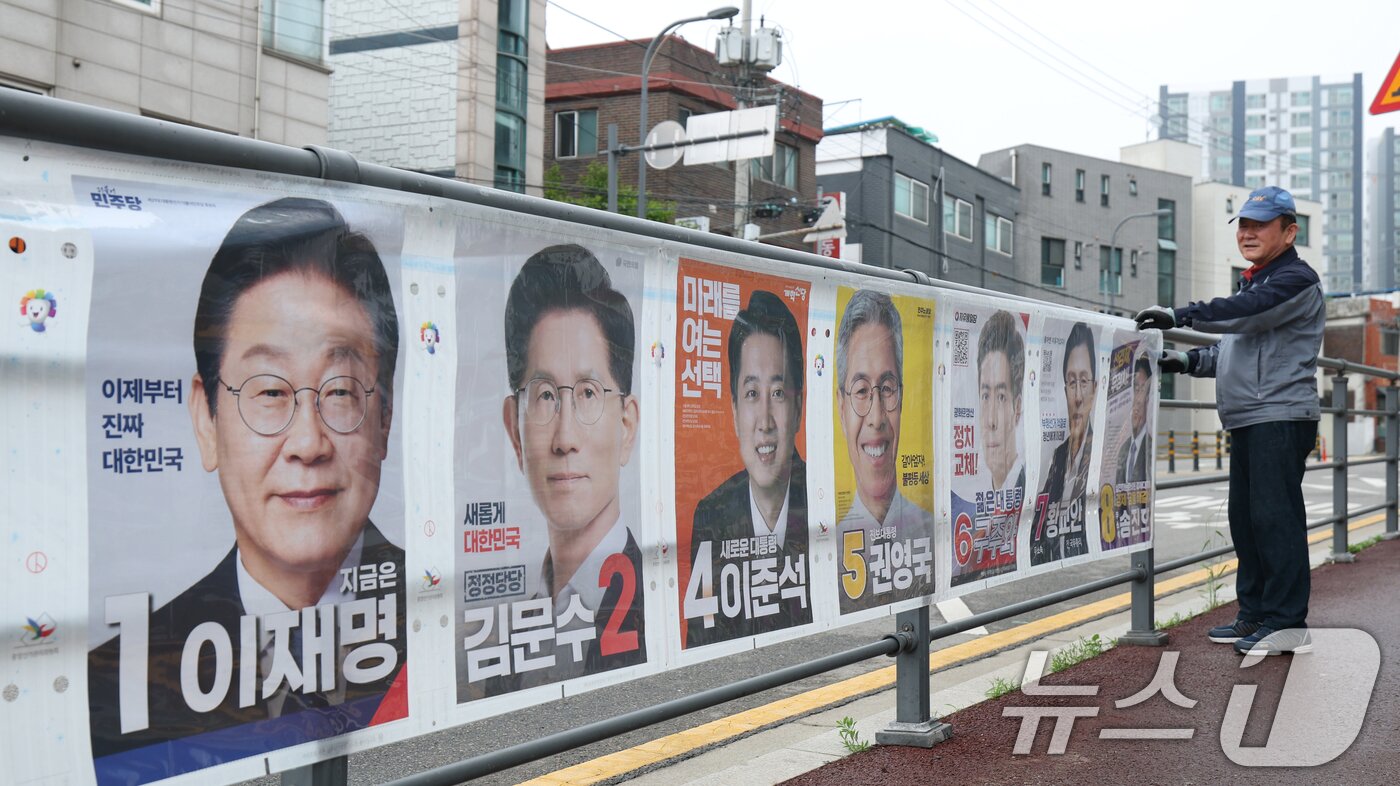 본문 이미지 - 15일 경기 수원시 권선구의 한 거리에서 관계자들이 제21대 대통령선거 후보자들 선거 벽보를 부착하고 있다. 2025.5.15/뉴스1 ⓒ News1 김영운 기자
