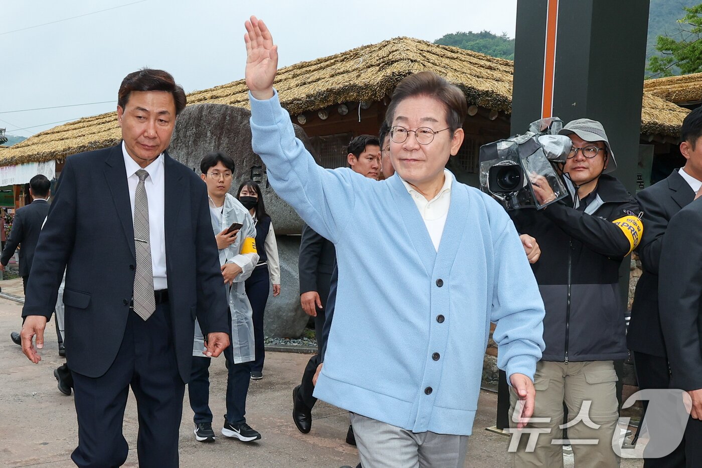 본문 이미지 - 이재명 더불어민주당 대통령 후보가 15일 오전 경남 하동군 화개장터 입구에서 광주 출신 30대 남성 문유성 씨, 대구 거주 20대 여성 김다니엘 씨와 유튜브 K-이니셔TV 케미폭발 &#39;동서화합&#39; 화개장터 라이브 오프닝을 마치고 이동하며 인사하고 있다. 2025.5.15/뉴스1 ⓒ News1 안은나 기자