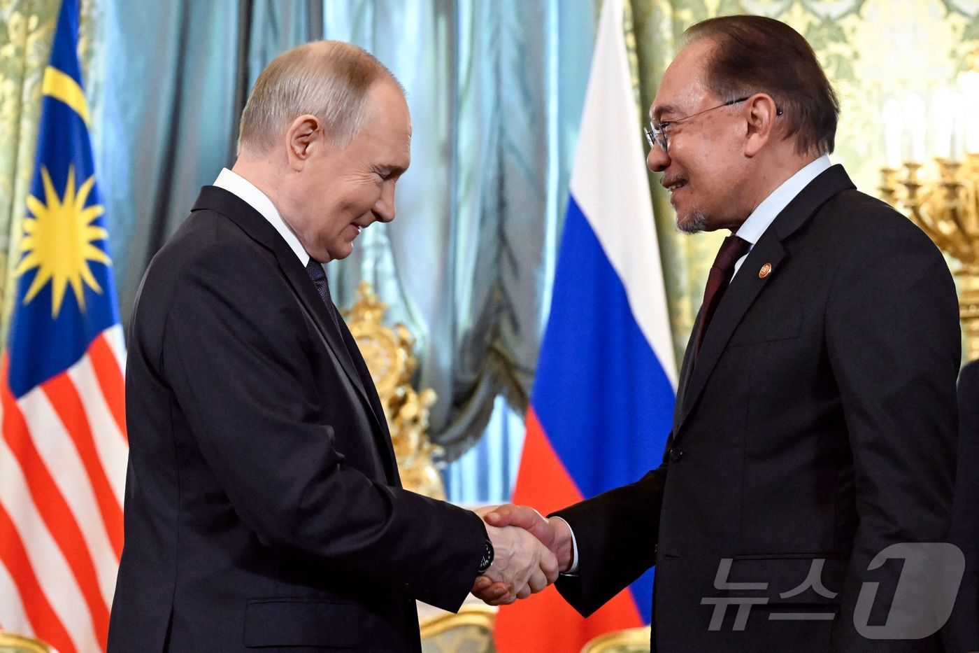 (모스크바 AFP=뉴스1) 우동명 기자 = 블라디미르 푸틴 러시아 대통령이 14일(현지시간) 모스크바 크렘린 궁에서 안와르 이브라힘 말레이시아 총리와 만나 악수를 하고 있다. 20 …