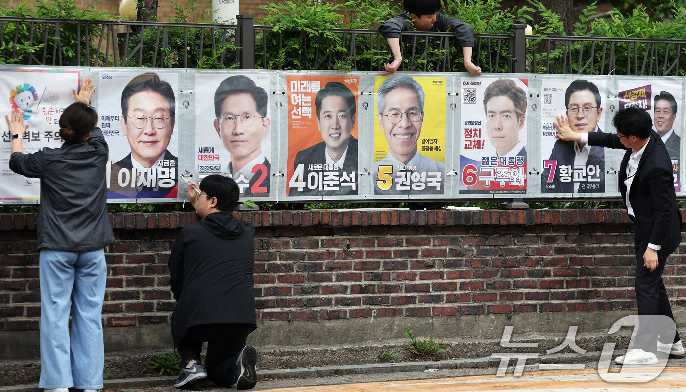 본문 이미지 - 서울시선거관리위원회 관계자들이 15일 오전 서울 종로구 예술가의집 담장에 제21대 대통령선거 선거벽보를 부착하고 있다. 선거벽보는 이날부터 전국 8만2900여 곳에 첩부된다. 2025.5.15/뉴스1 ⓒ News1 오대일 기자
