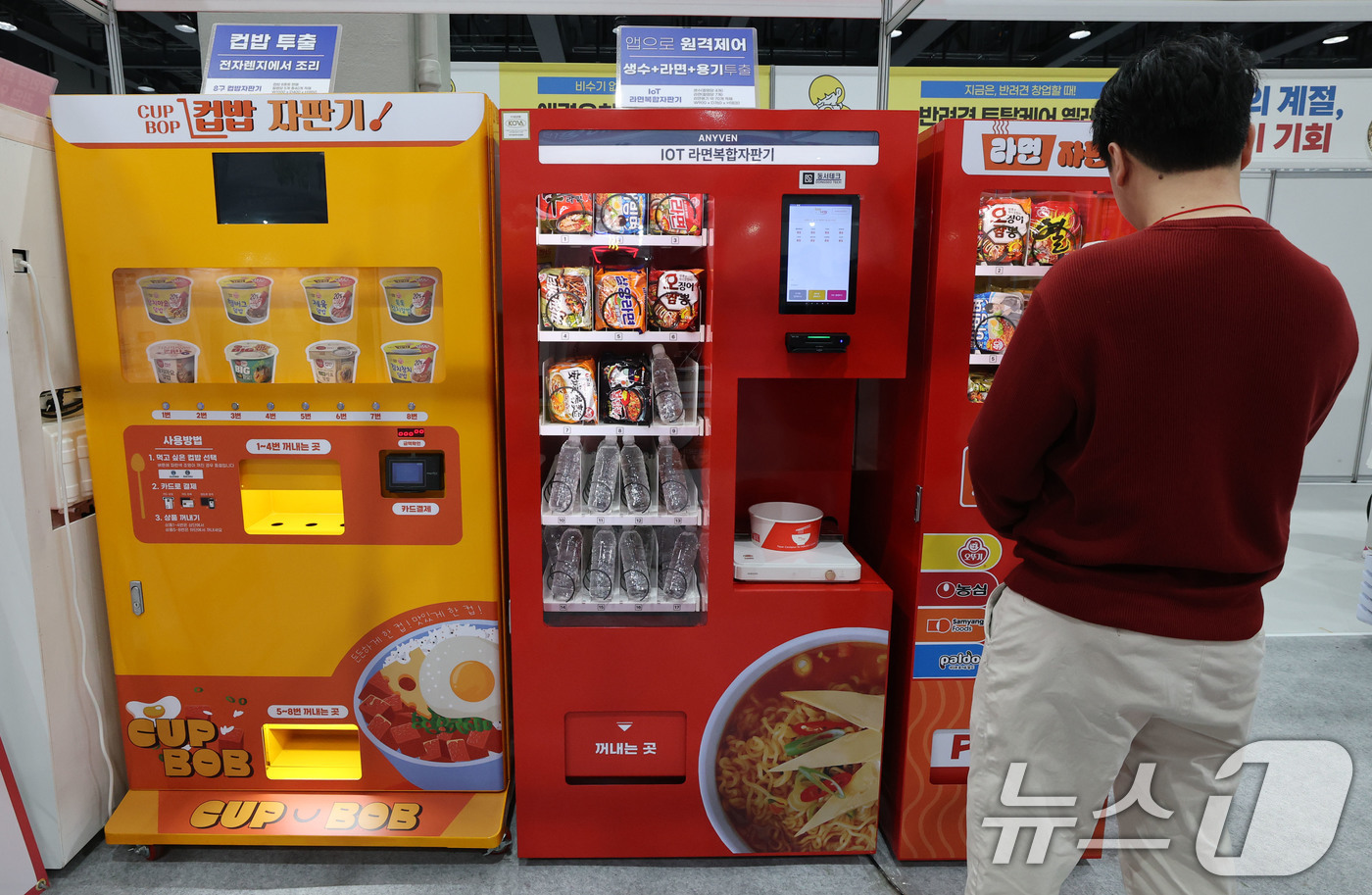 (서울=뉴스1) 박세연 기자 = 15일 서울 강서구 코엑스 마곡에서 열린 ‘제78회 프랜차이즈 창업박람회 2025’를 찾은 예비창업자가 라면, 컵밥 등 무인 자판기를 살펴보고 있다 …