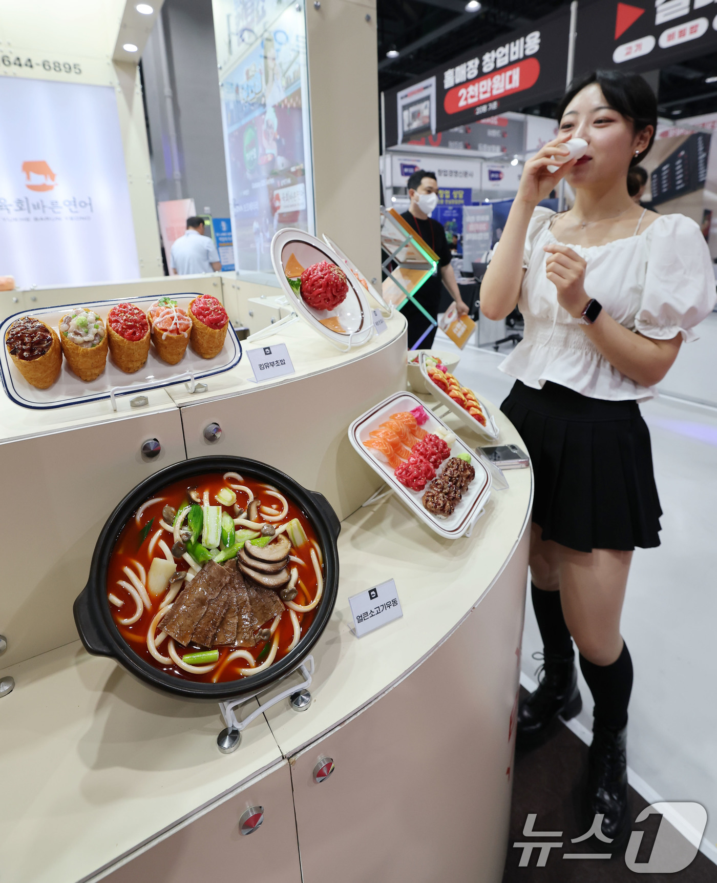 (서울=뉴스1) 박세연 기자 = 15일 서울 강서구 코엑스 마곡에서 열린 ‘제78회 프랜차이즈 창업박람회 2025’를 찾은 관람객이 한 음식 프랜차이즈부스에서 시식을 하고 있다.프 …