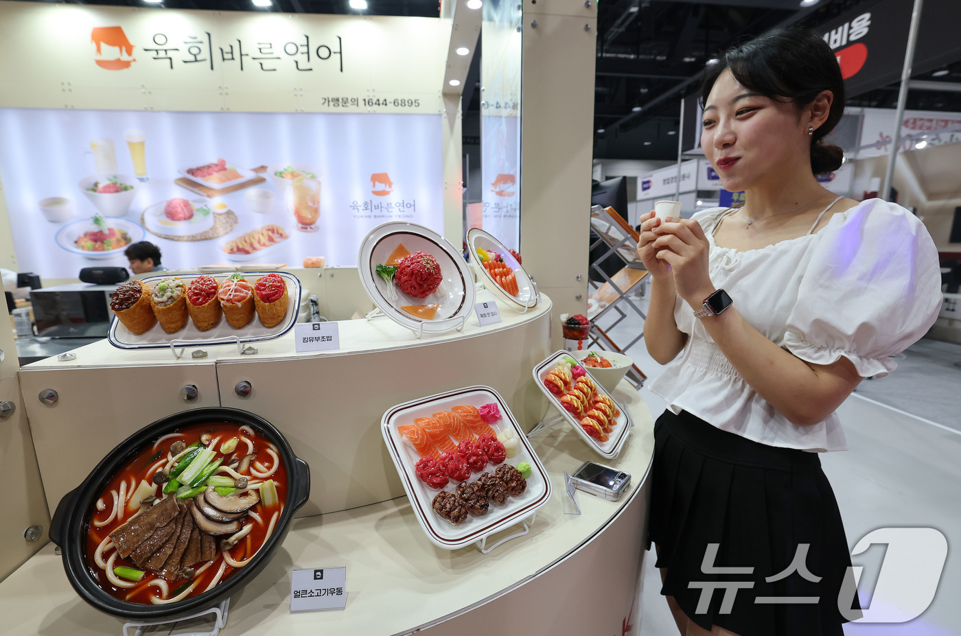 (서울=뉴스1) 박세연 기자 = 15일 서울 강서구 코엑스 마곡에서 열린 ‘제78회 프랜차이즈 창업박람회 2025’를 찾은 관람객이 한 음식 프랜차이즈부스에서 시식을 하고 있다.프 …