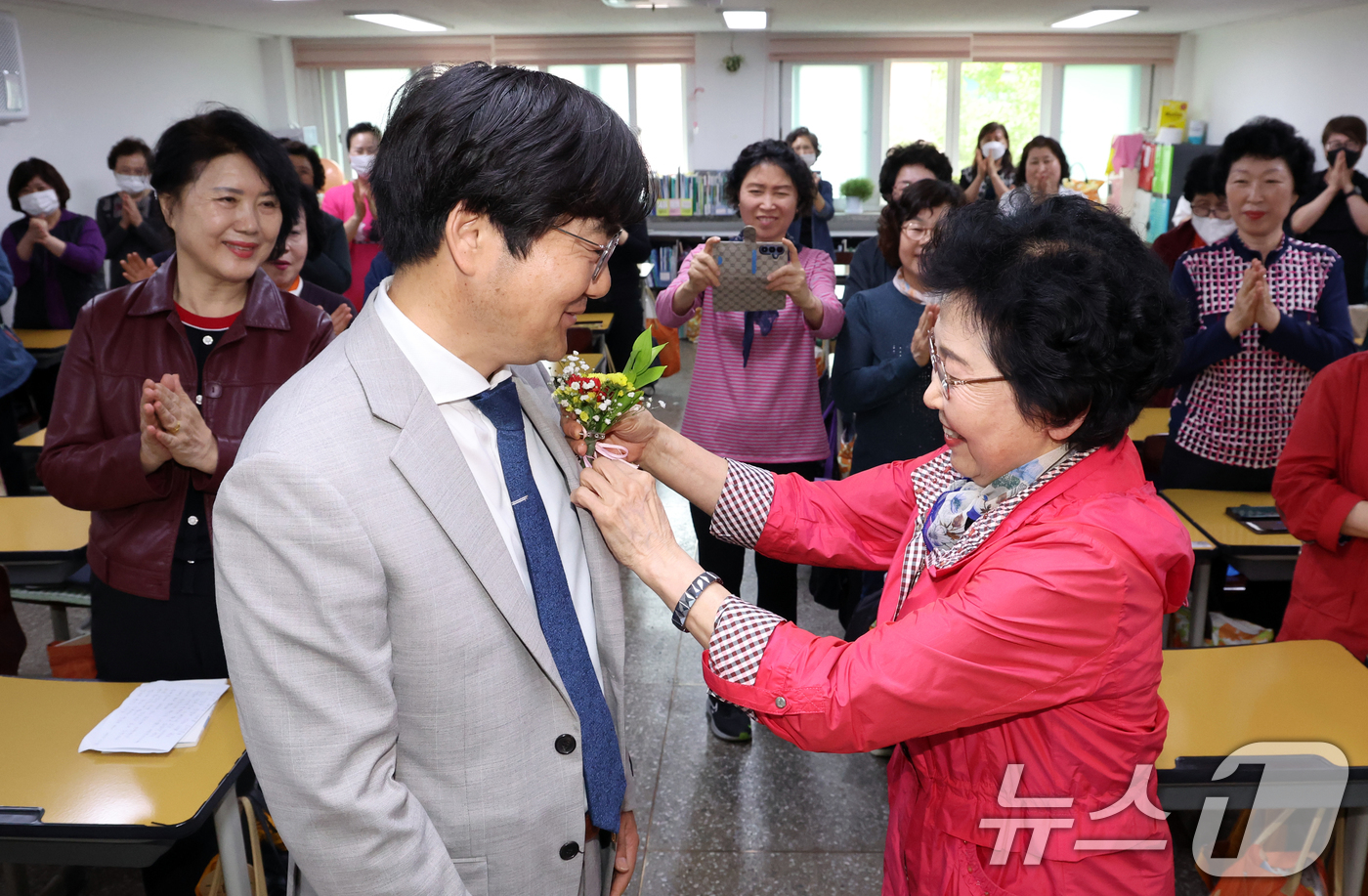 (서울=뉴스1) 김명섭 기자 = 스승의 날인 15일 서울 마포구 일성여자고등학교 1학년 2반에서 학생이 고형구 담임선생님에게 꽃을 달아 드리고 있다.일성여자중고등학교는 개인적인 사 …