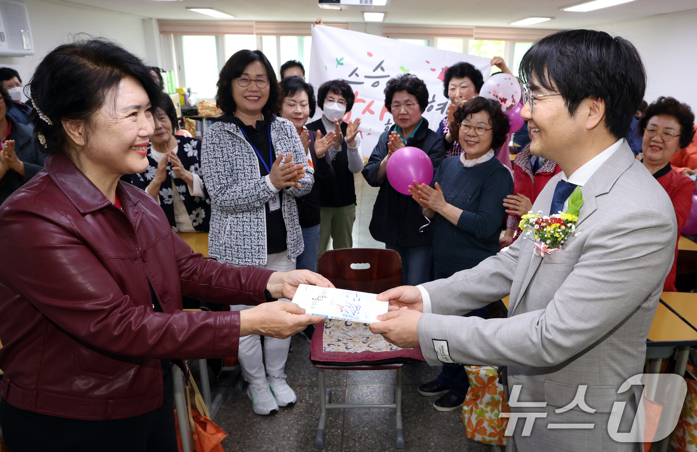 (서울=뉴스1) 김명섭 기자 = 스승의 날인 15일 서울 마포구 일성여자고등학교 1학년 2반에서 졸업생이 직접 쓴 시집을 고형구 담임선생님에게 선물로 전달하고 있다.일성여자중고등학 …