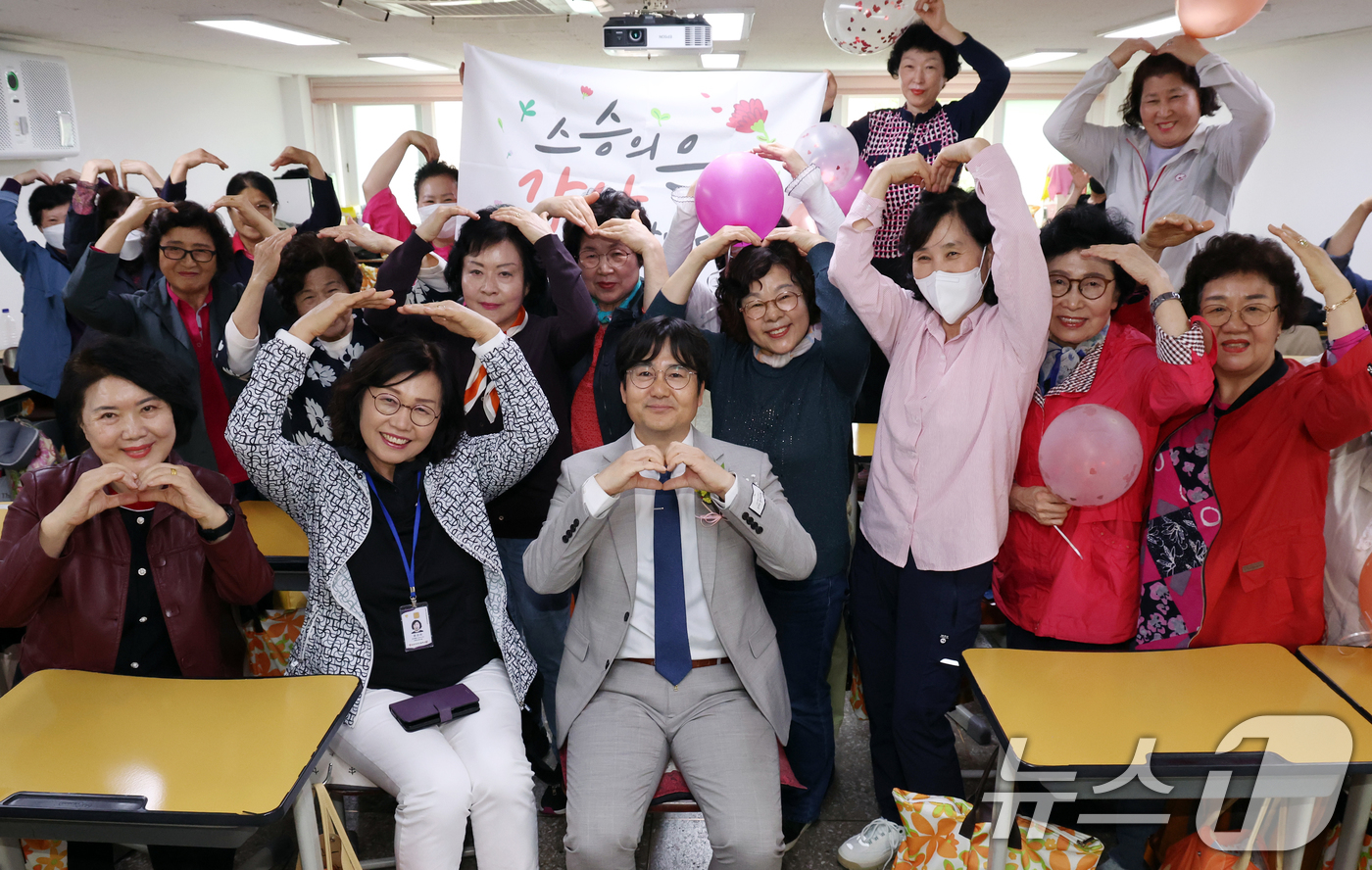 (서울=뉴스1) 김명섭 기자 = 스승의 날인 15일 서울 마포구 일성여자고등학교 1학년 2반 학생들이 고형구 담임선생님과 함께 하트를 만들어 보이고 있다.일성여자중고등학교는 개인적 …