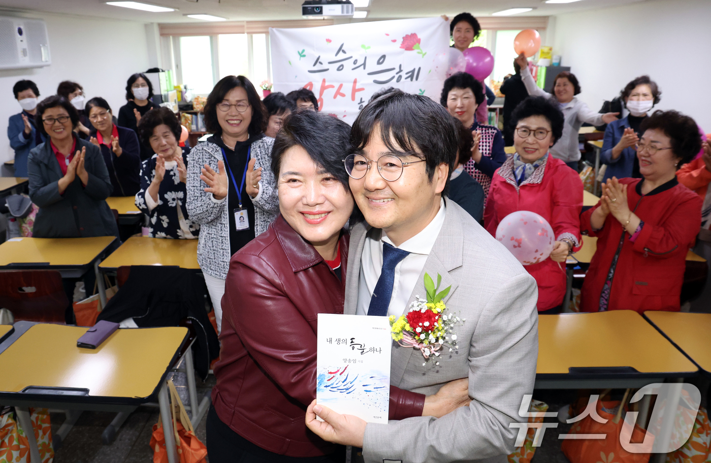 (서울=뉴스1) 김명섭 기자 = 스승의 날인 15일 서울 마포구 일성여자고등학교 1학년 2반에서 졸업생이 직접 쓴 시집을 고형구 담임선생님에게 선물로 드리고 포옹하고 있다.일성여자 …