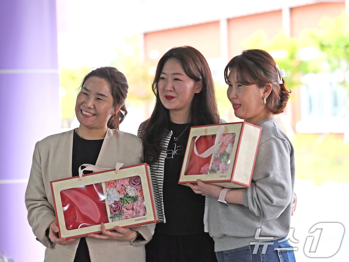 (광주=뉴스1) 박지현 기자 = 스승의날을 맞은 15일 광주 북구 매곡동에 위치한 광주예술고에서 교사들이 학생들에게 받은 꽃과 함께 기념사진을 남기고 있다. 2025.5.15/뉴스 …