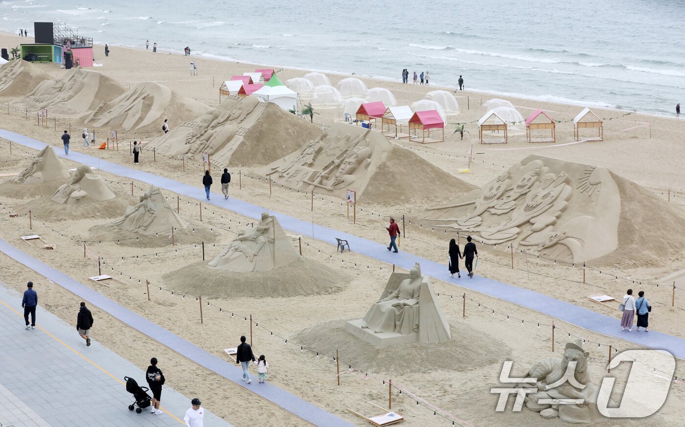 본문 이미지 - 15일 오후 부산 해운대해수욕장을 찾은 시민, 관광객들이 다양한 모래조각 작품을 구경하고 있다. ⓒ News1 윤일지 기자