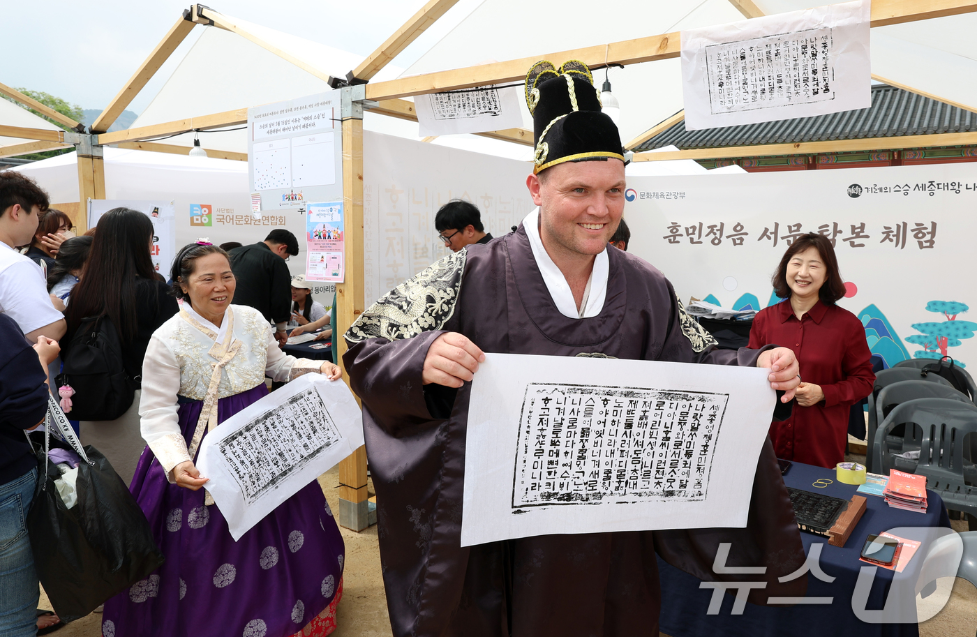 (서울=뉴스1) 김명섭 기자 = 15일 경복궁 흥례문 앞 광장에서 ‘628돌 세종대왕 나신 날 기념행사’에서 외국인 관광객들이 훈민정음 서문 탁본 체험을 하고 있다.‘세종대왕 나신 …