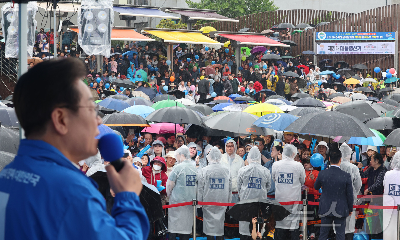 (여수=뉴스1) 안은나 기자 = 15일 오후 전남 여수시 이순신 광장에서 우산과 우비를 쓴 시민들이 이재명 더불어민주당 대통령 후보의 연설을 지켜보고 있다. (공동취재) 2025. …