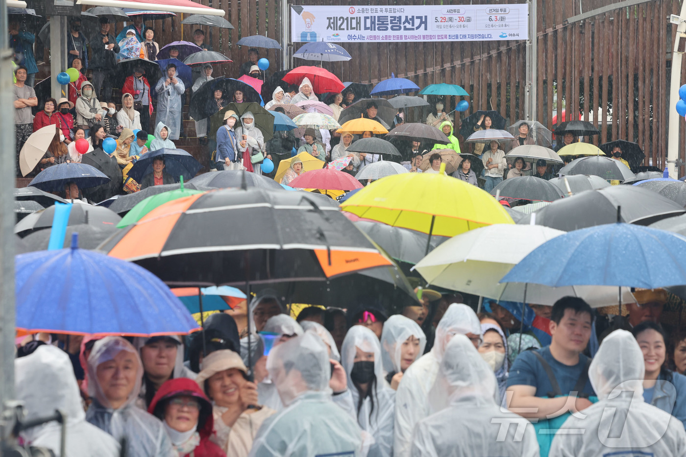 (여수=뉴스1) 안은나 기자 = 15일 오후 전남 여수시 이순신 광장에서 우산과 우비를 쓴 시민들이 이재명 더불어민주당 대통령 후보의 연설을 지켜보고 있다. (공동취재) 2025. …