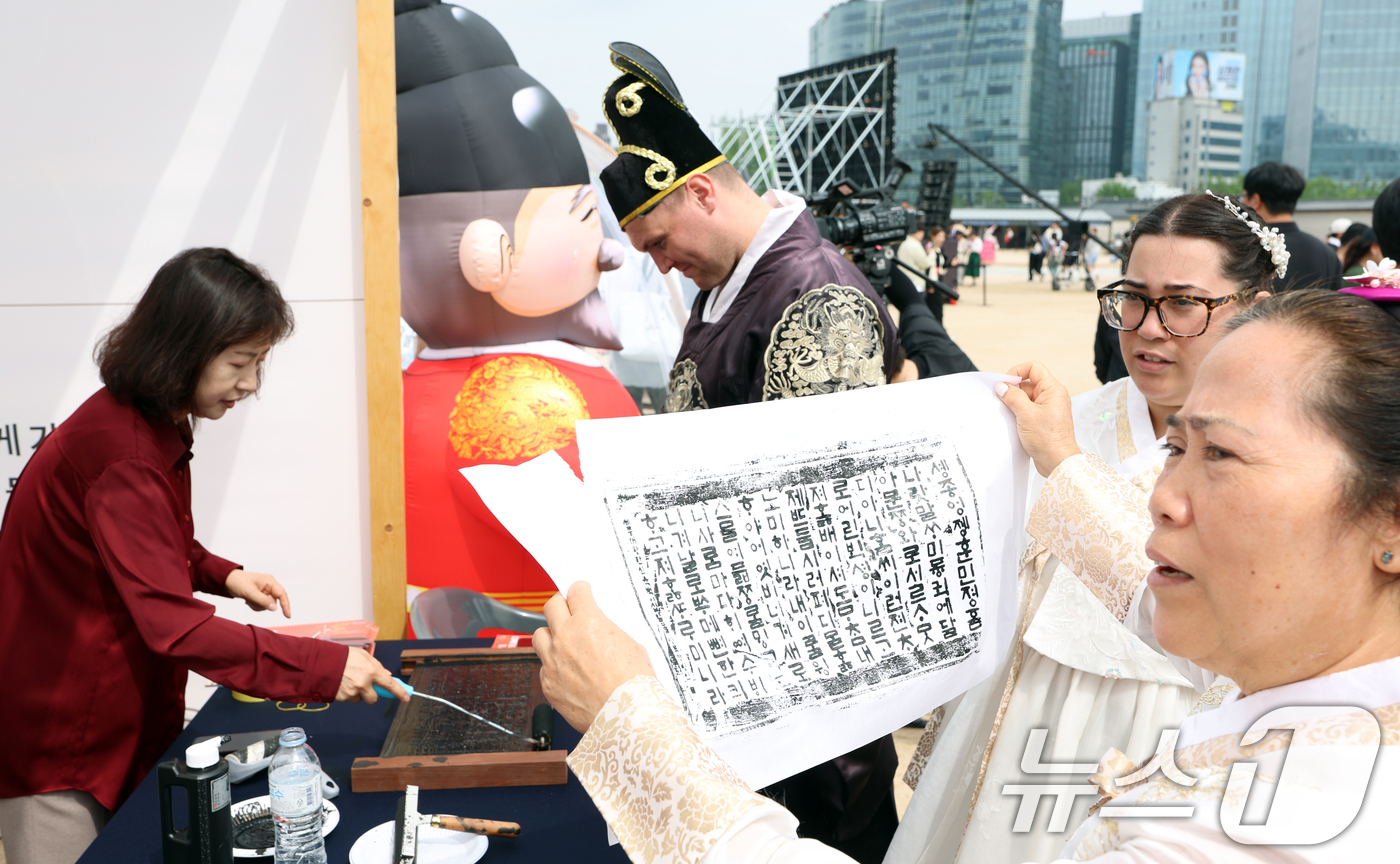 (서울=뉴스1) 김명섭 기자 = 15일 경복궁 흥례문 앞 광장에서 ‘628돌 세종대왕 나신 날 기념행사’에서 외국인 관광객들이 훈민정음 서문 탁본 체험을 하고 있다.‘세종대왕 나신 …