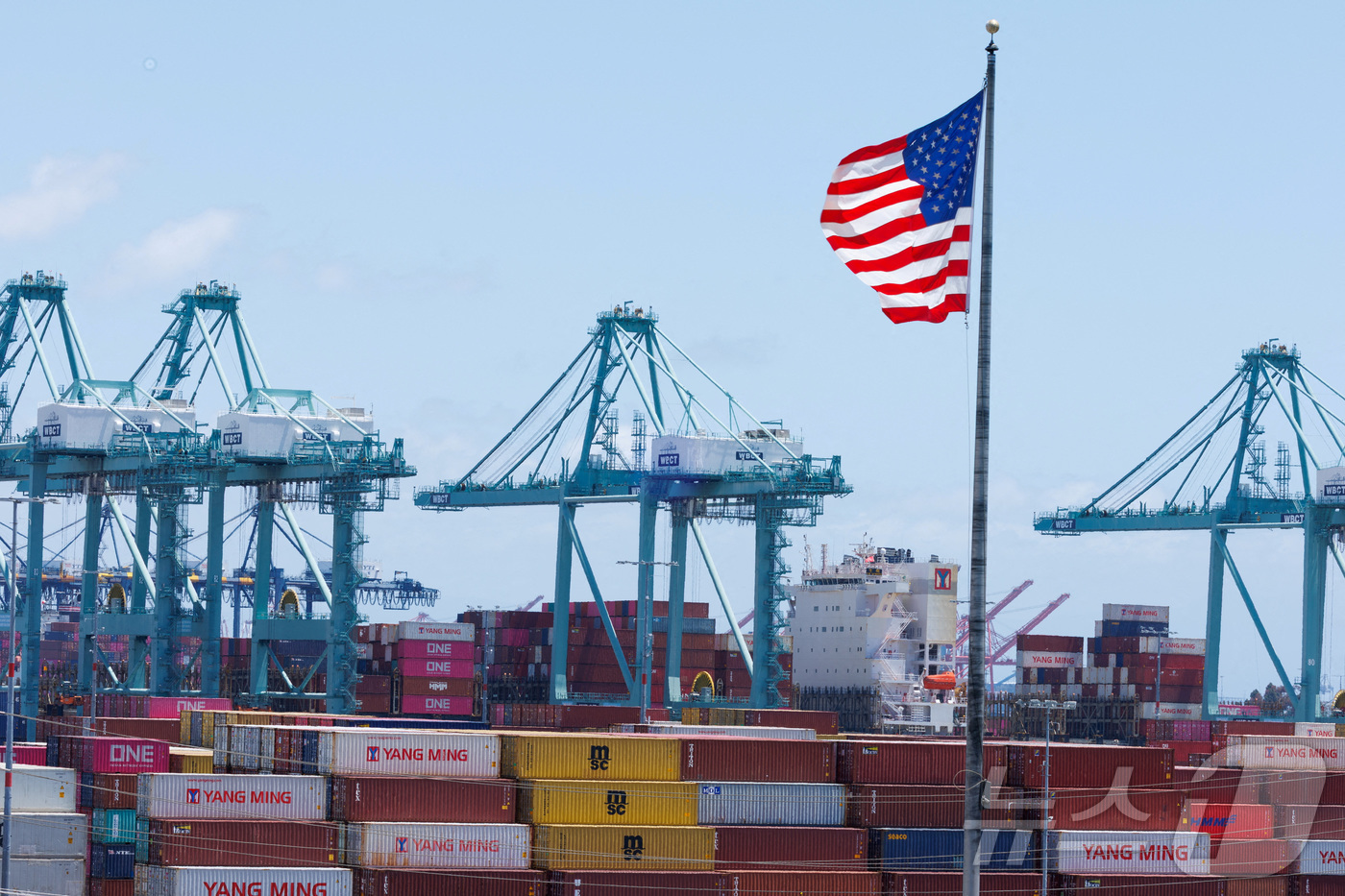 (로스앤젤레스 로이터=뉴스1) 권영미 기자 = 미국 캘리포니아주 로스앤젤레스항에 선적된 컨테이너 위로 미국 성조기가 나부끼고 있다. 2025.05.13.ⓒ 로이터=뉴스1