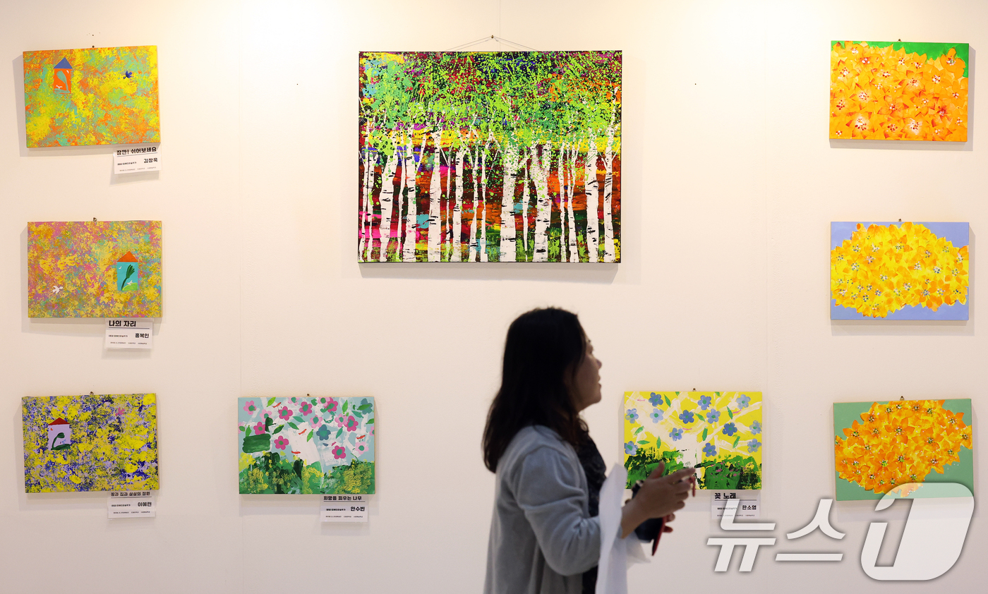 (서울=뉴스1) 오대일 기자 = 15일 오후 서울 강남구 세텍(SETEC)에서 열린 2025 서울 아트페어에서 관람객들이 발달장애인 작가 100인의 작품을 감상하고 있다.국내외 현 …