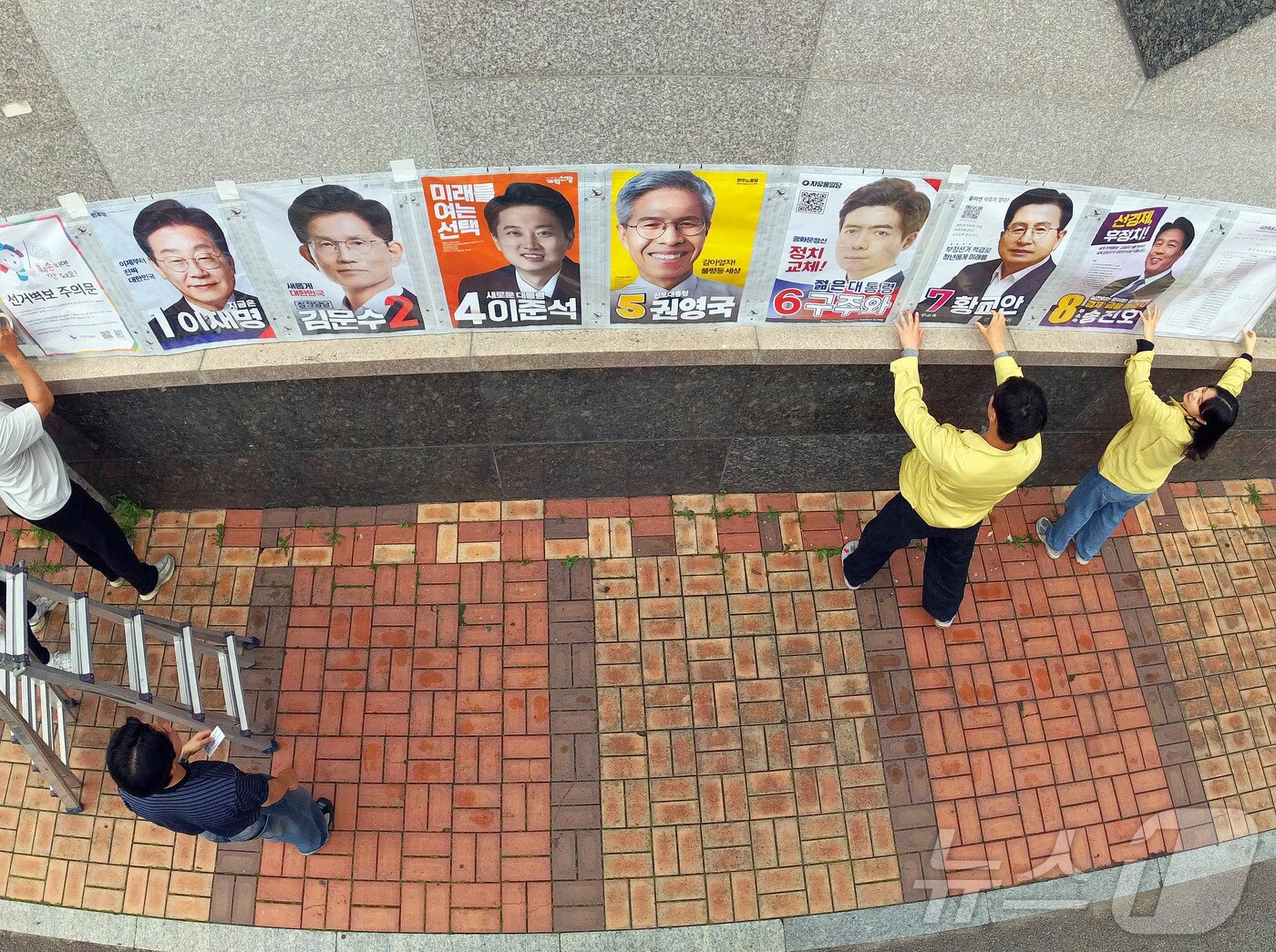 본문 이미지 - 제21대 대통령 선거 벽보 부착 시작 첫날인 15일 광주 북구 운암사거리 인근에서 운암1동 행정복지센터 직원들과 관계자들이 후보자들의 벽보를 붙이고 있다.&#40;광주 북구 제공. 재판매 및 DB 금지&#41; 2025.5.15/뉴스1 ⓒ News1 박지현 기자
