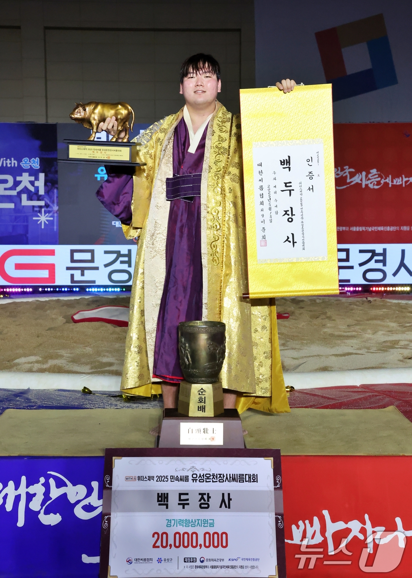 (서울=뉴스1) = 15일 대전광역시 유성구 국립한밭대학교 체육관에서 열린 '위더스제약 2025 민속씨름 유성온천장사씨름대회'에서 백두장사에 등극한 최성민이 장사인증서와 황소트로피 …