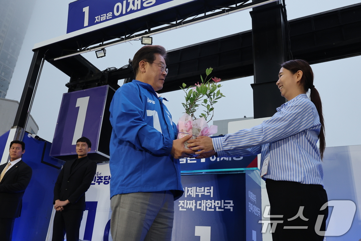 (목포=뉴스1) 안은나 기자 = 이재명 더불어민주당 대통령 후보가 '이순신 호국 벨트' 유세차 15일 오후 전남 목포시 평화광장을 찾아 인동초를 선물 받고 있다. 2025.5.15 …