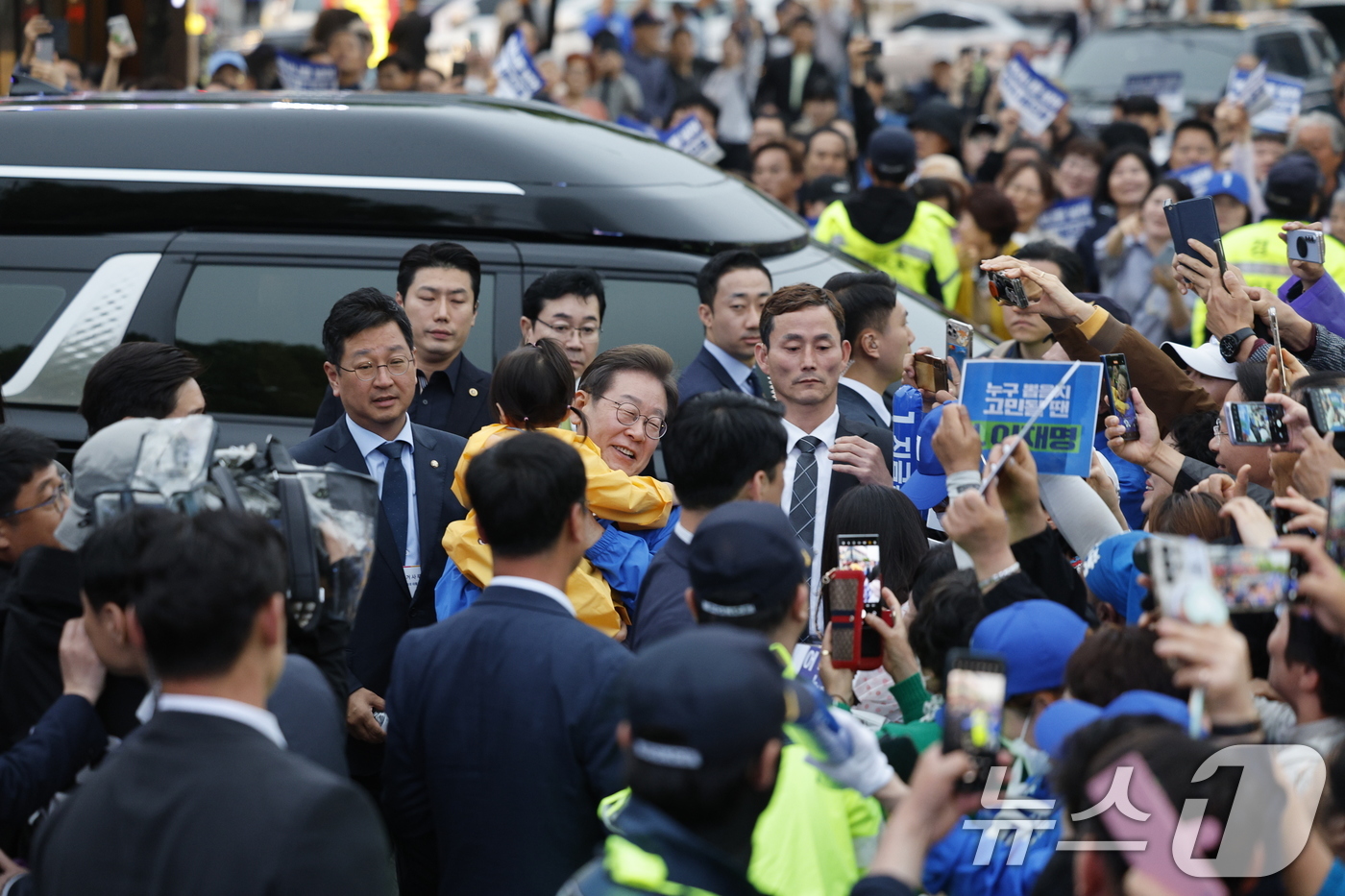 (목포=뉴스1) 안은나 기자 = 이재명 더불어민주당 대통령 후보가 '이순신 호국 벨트' 유세차 15일 오후 전남 목포시 평화광장을 찾아 어린이를 안은 채 이동하고 있다. 2025. …