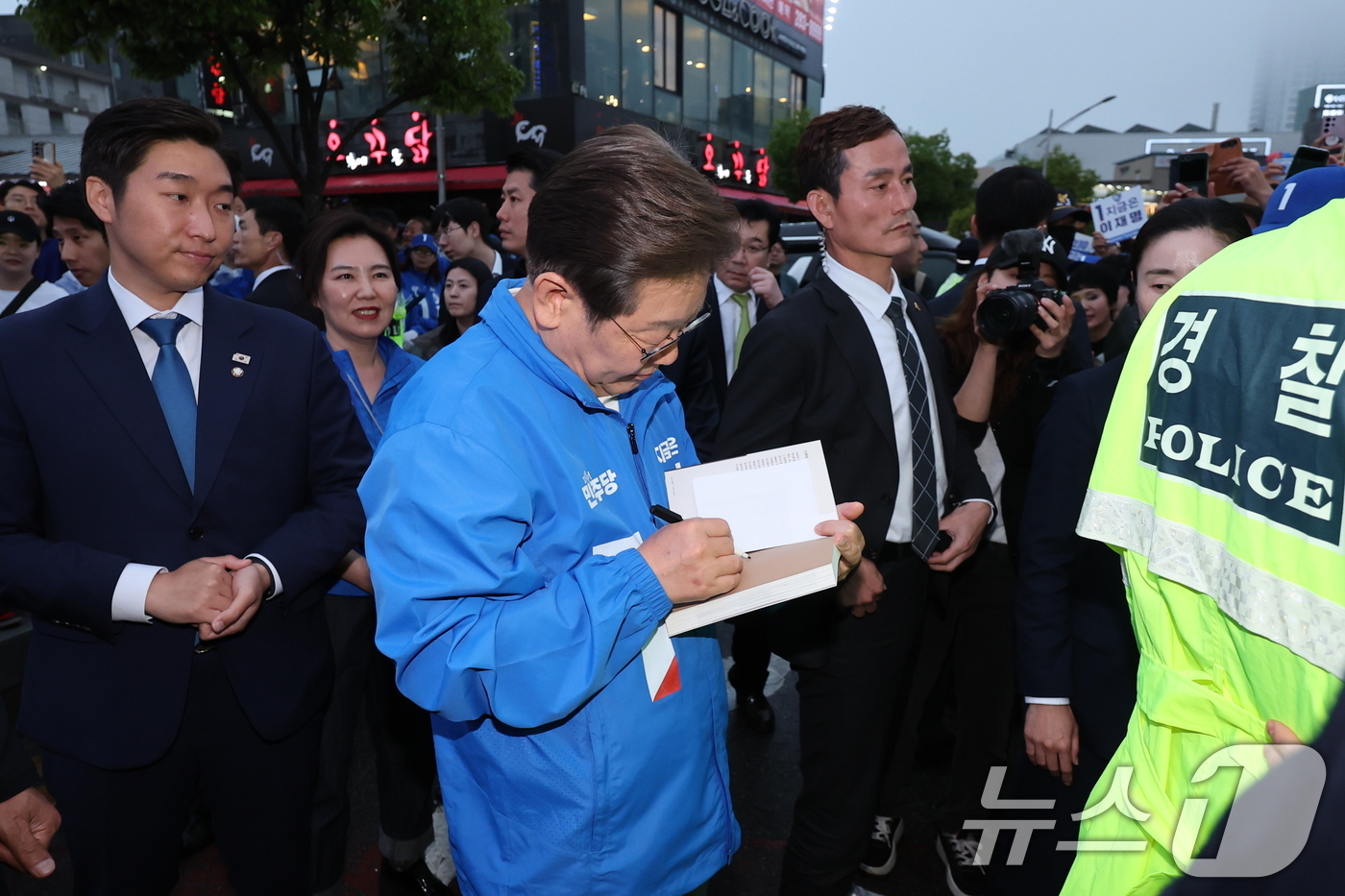 (목포=뉴스1) 안은나 기자 = 이재명 더불어민주당 대통령 후보가 '이순신 호국 벨트' 유세차 15일 오후 전남 목포시 평화광장을 찾아 책에 사인을 하고 있다. 2025.5.15/ …