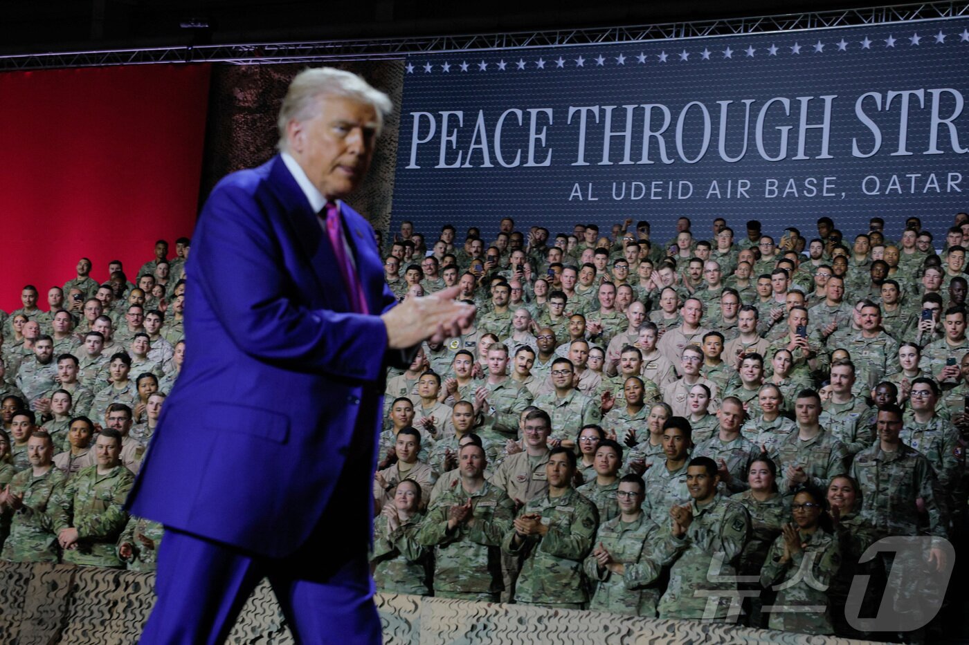 본문 이미지 - 작년 5월 도널드 트럼프 미국 대통령이 카타르 도하의 알우데이드 공군기지를 방문하는 동안 "힘을 통한 평화＂라는 배너 옆을 지나가고 있다. 2025.5.15 ⓒ 로이터=뉴스1 ⓒ News1 강민경 기자