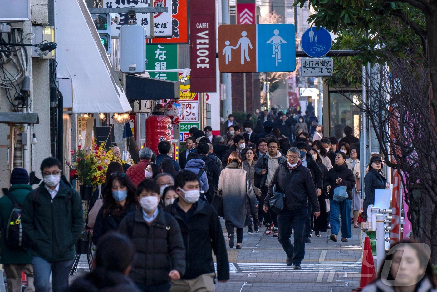 (도쿄 AFP=뉴스1) = 2025년 2월 17일 도쿄의 보도를 따라 사람들이 걷고 있다. 일본 내각부가 16일 발표한 자료에 따르면 일본 경제는 지난 1분기(1~3월)동안 0.2 …