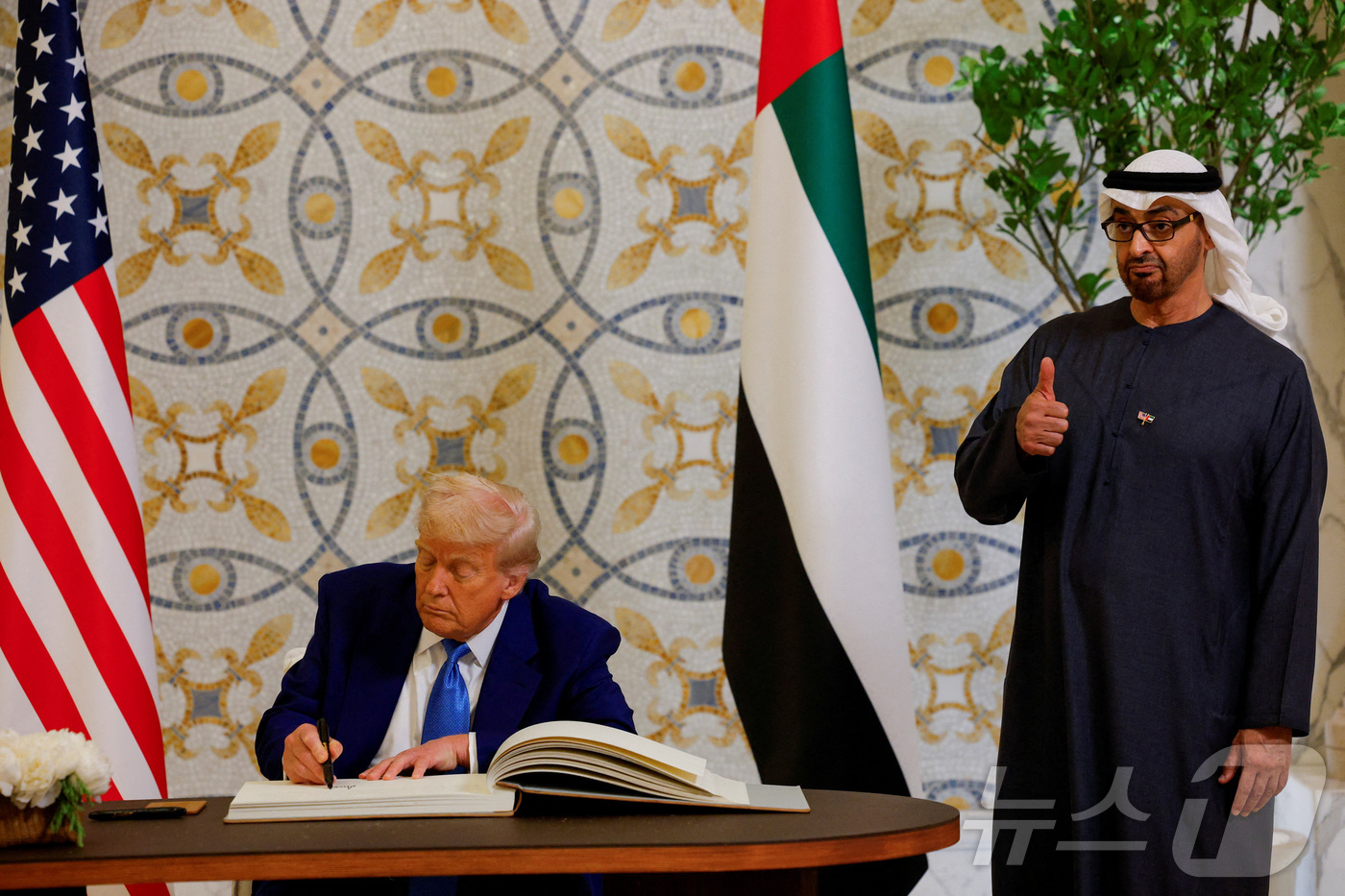 (아부다비 로이터=뉴스1) 우동명 기자 = 도널드 트럼프 미국 대통령이 15일(현지시간) 아부다비의 대통령 궁에서 방명록에 서명을 하는 동안 셰이크 무함마드 빈 자이드 알 나흐얀 …