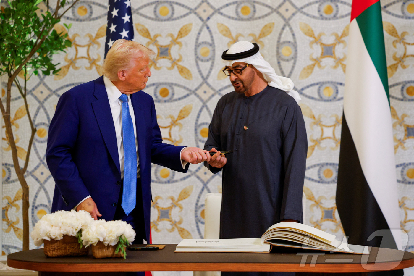 (아부다비 로이터=뉴스1) 우동명 기자 = 도널드 트럼프 미국 대통령이 15일(현지시간) 아부다비의 대통령 궁에서 방명록에 서명을 한 뒤 셰이크 무함마드 빈 자이드 알 나흐얀 UA …