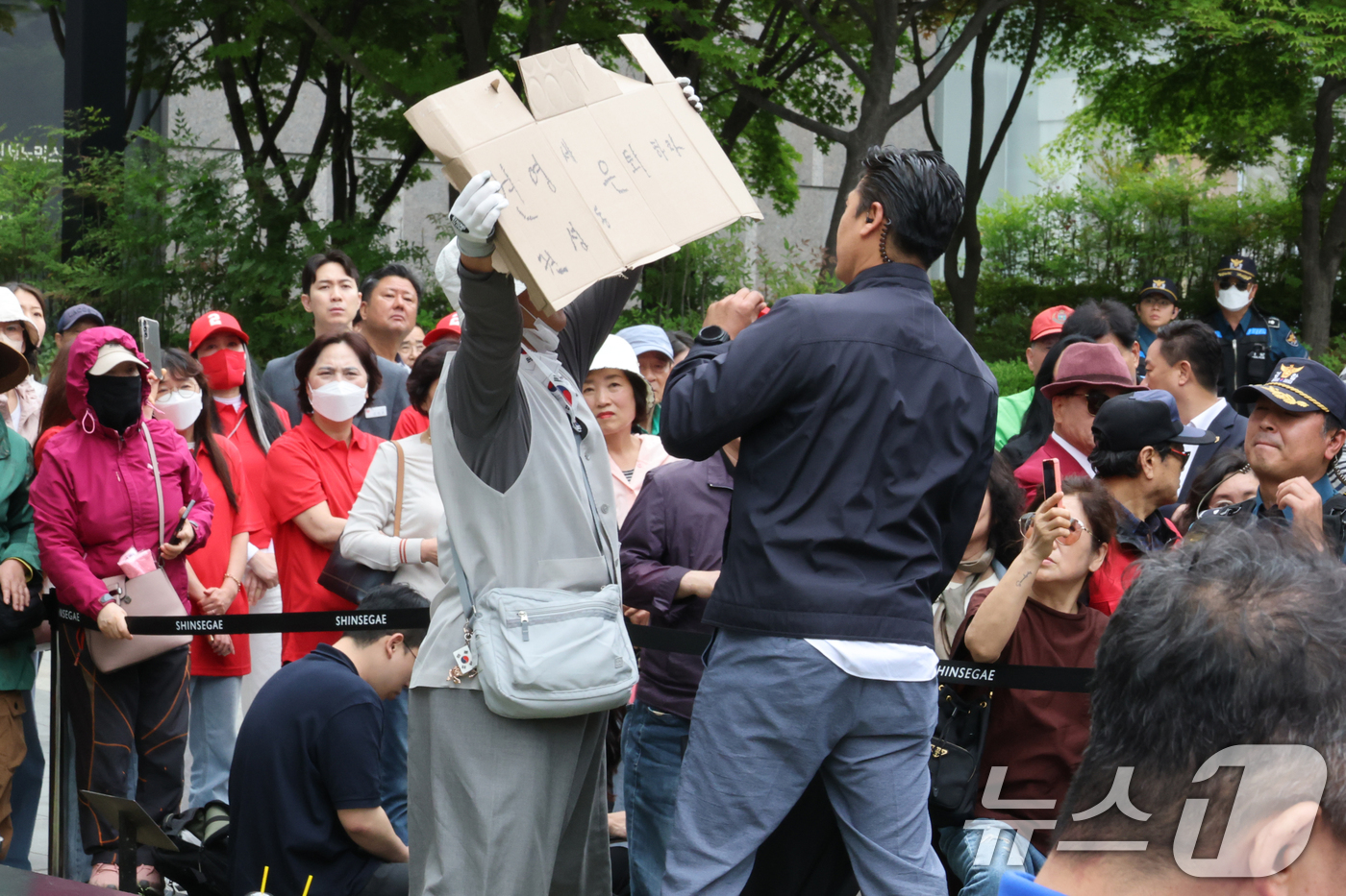 (천안=뉴스1) 이광호 기자 = 16일 오후 충남 천안시 동남구 신세계백화점 앞에서 열린 김문수 국민의힘 대통령 후보의 유세에서 한 시민이 '권영세, 권성동 은퇴하라'라고 적힌 피 …