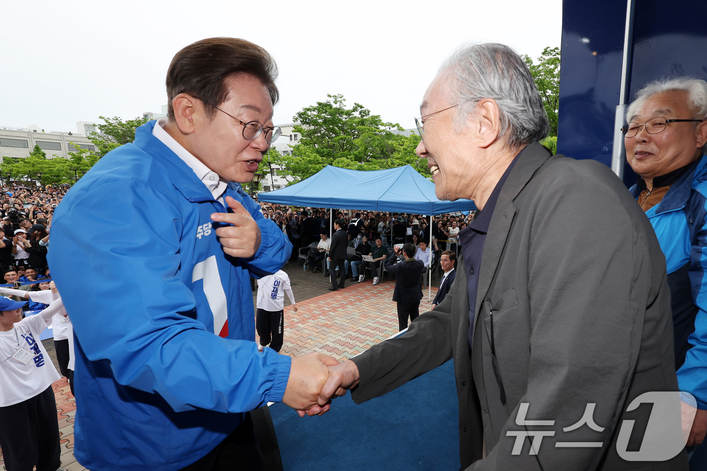 (군산=뉴스1) 이재명 기자 = 이재명 더불어민주당 대통령 후보가 16일 오후 전북 군산시 구시청광장에서 확성영 작가와 악수하고 있다. (공동취재) 2025.5.16/뉴스1