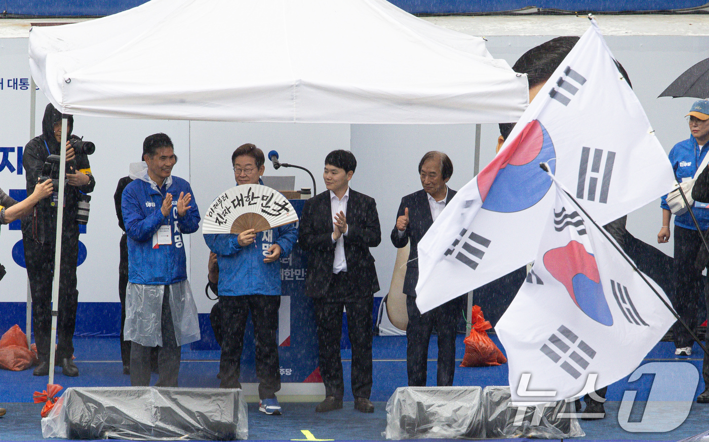 (전주=뉴스1) 이재명 기자 = 이재명 더불어민주당 대통령 후보가 16일 오후 전북 전주시 전북대학교 앞에서 '이제부터 진짜 대한민국'이 적힌 전주 한지 부채(합죽선)를 들어보이고 …