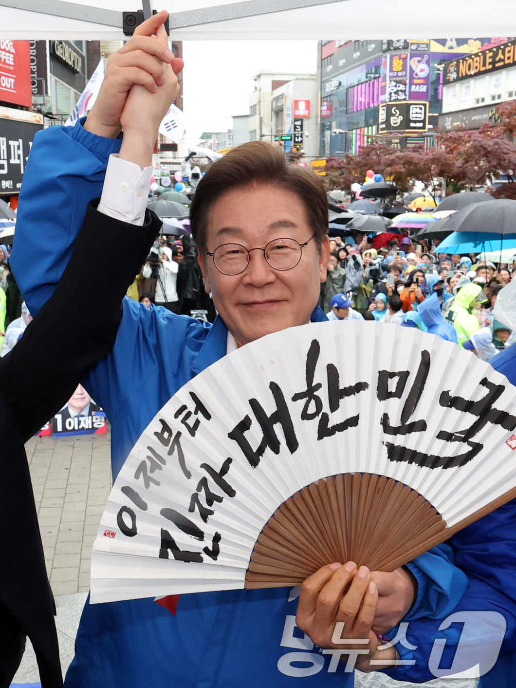 (전주=뉴스1) 이재명 기자 = 이재명 더불어민주당 대통령 후보가 16일 오후 전북 전주시 전북대학교 앞에서 '이제부터 진짜 대한민국'이 적힌 전주 한지 부채(합죽선)를 들어보이고 …