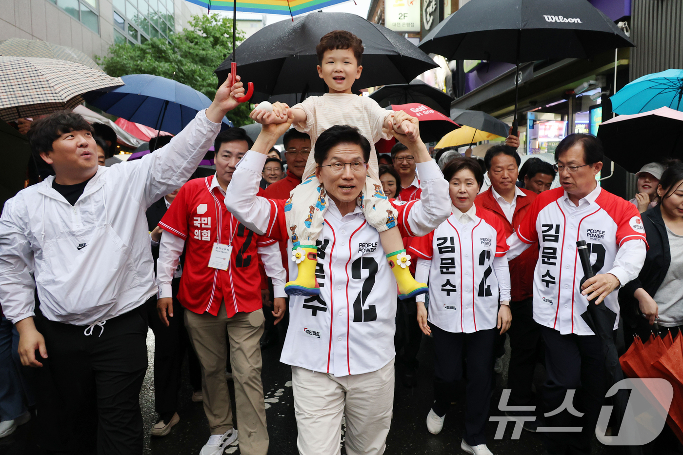 (대전=뉴스1) 이광호 기자 = 김문수 국민의힘 대통령 후보가 16일 오후 대전 중구 으능정이거리에서 한 시민의 아이를 목마 태우고 유세차량으로 이동하고 있다. 2025.5.16/ …
