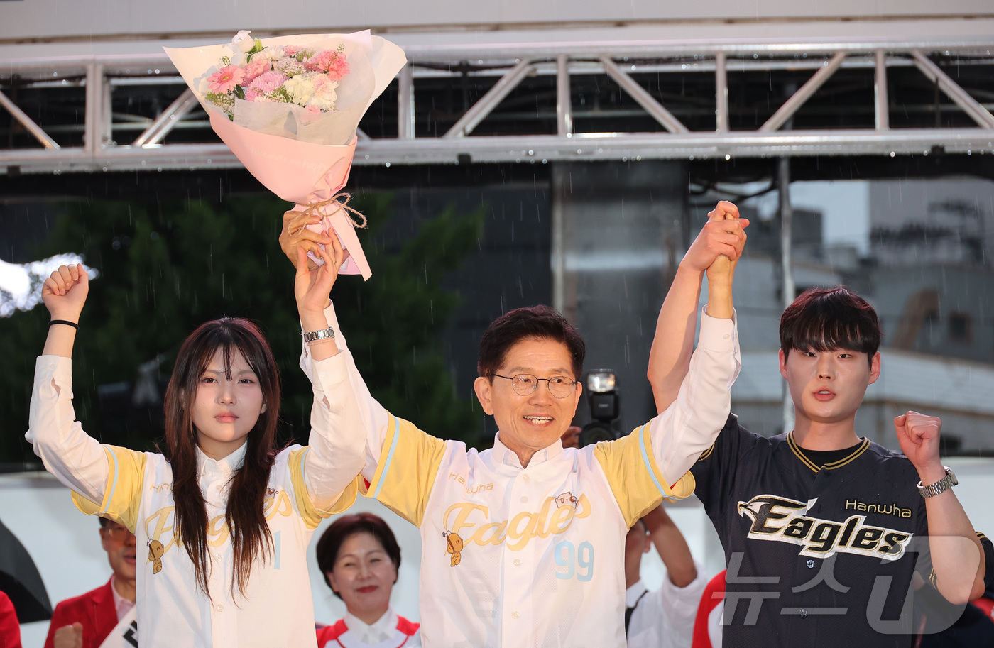 (대전=뉴스1) 이광호 기자 = 김문수 국민의힘 대통령 후보가 16일 오후 대전 중구 으능정이거리에서 가진 유세에서 한화이글스 유니폼을 선물한 대학생들과 함께 손을 맞잡고 있다. …