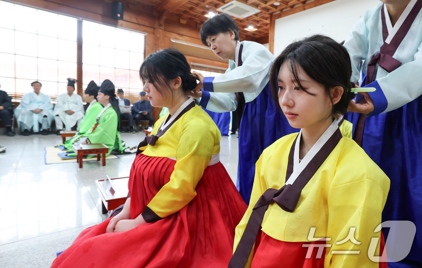 (서울=뉴스1) 박세연 기자 = 17일 오전 서울 동대문구 서울한방진흥센터 대강당에서 열린 제14회 동대문구 전통 성년례에서 참가자들이 여자에게 쪽을 찌고 비녀를 꽂는 계례(筓禮) …