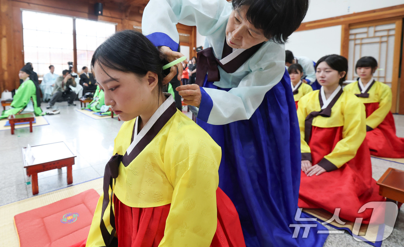 (서울=뉴스1) 박세연 기자 = 17일 오전 서울 동대문구 서울한방진흥센터 대강당에서 열린 제14회 동대문구 전통 성년례에서 참가자들이 여자에게 쪽을 찌고 비녀를 꽂는 계례(筓禮) …