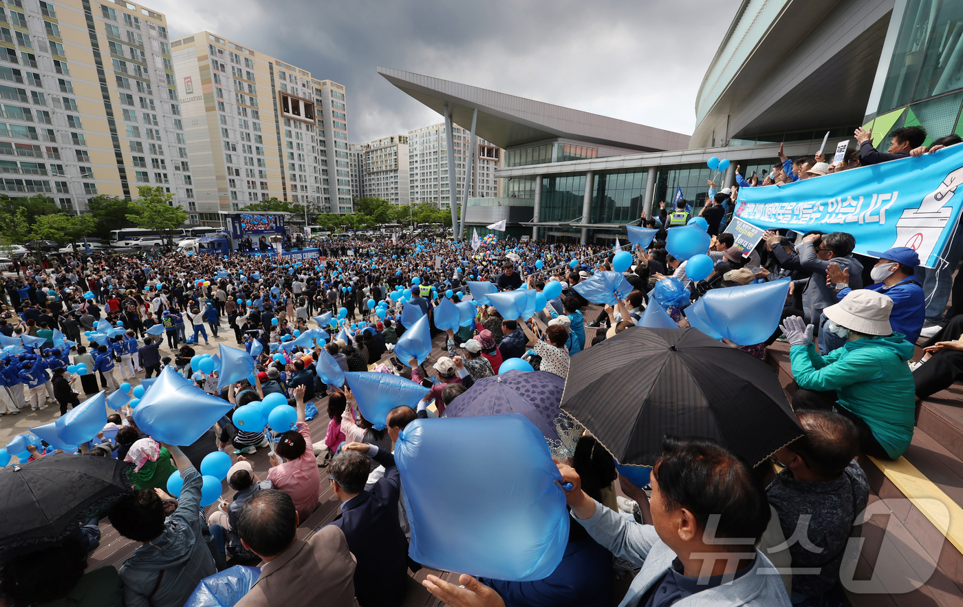 (광주=뉴스1) 이재명 기자 = 17일 광주 서구 김대중컨벤션센터 광장에서 열린 이재명 더불어민주당 대통령 후보 집중유세에서 시민들이 유세를 지켜보며 파란 풍선과 봉지를 흔들고 있 …