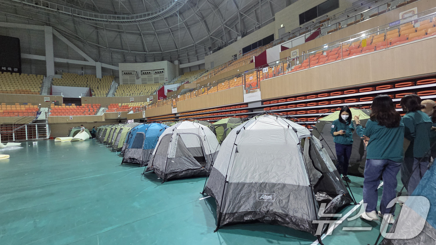 (광주=뉴스1) 이승현 기자 = 17일 오전 발생한 금호타이어 광주공장 화재 여파로 검은 연기가 퍼지면서 대피를 희망하는 주민들을 위해 광산구 공무원들이 광주여대 체육관에 400세 …