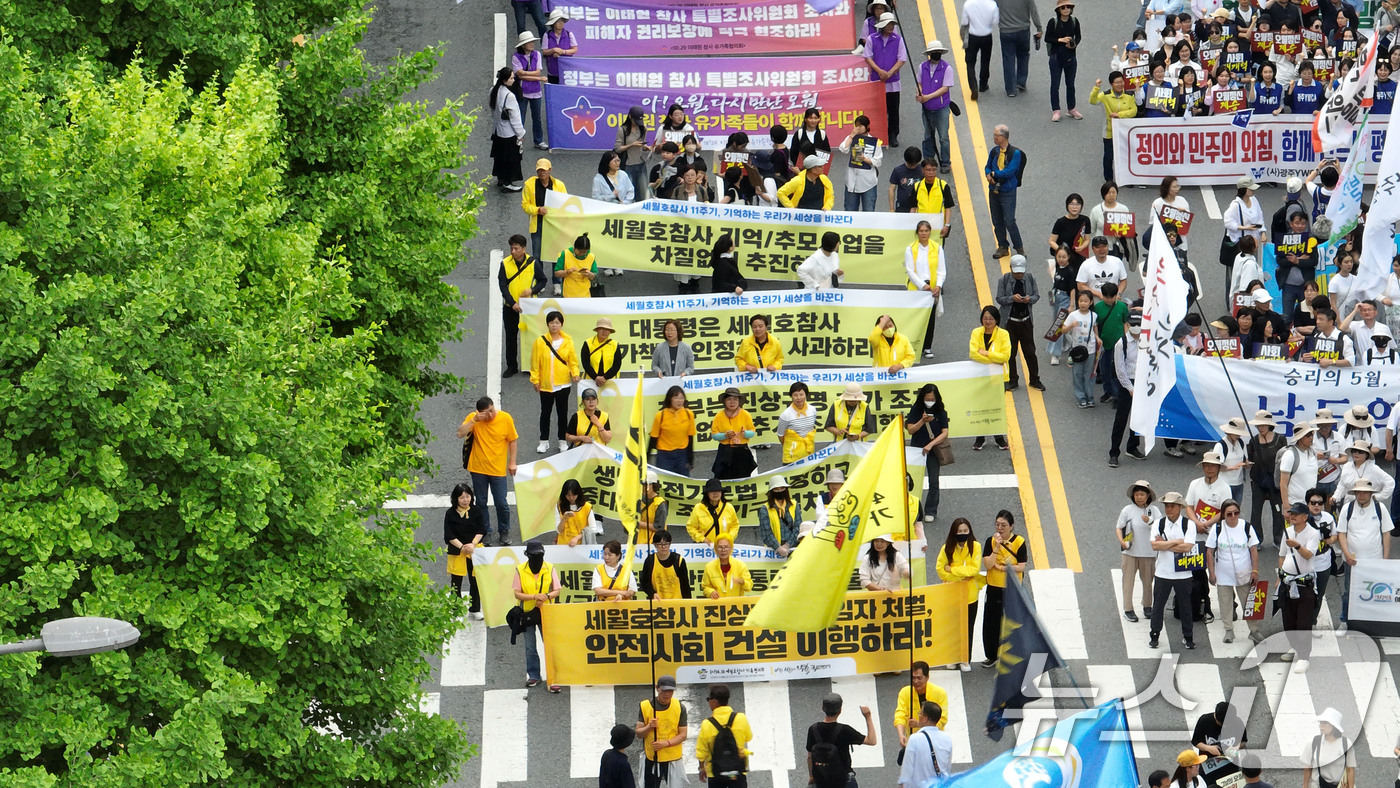 (광주=뉴스1) 김태성 기자 = 5·18 민주화운동 45주년을 하루 앞두고 17일 오후 광주 동구 금남로 일대에서 세월호유가족협의회가 민주평화대행진에서 현수막을 든 채 걷고 있다. …