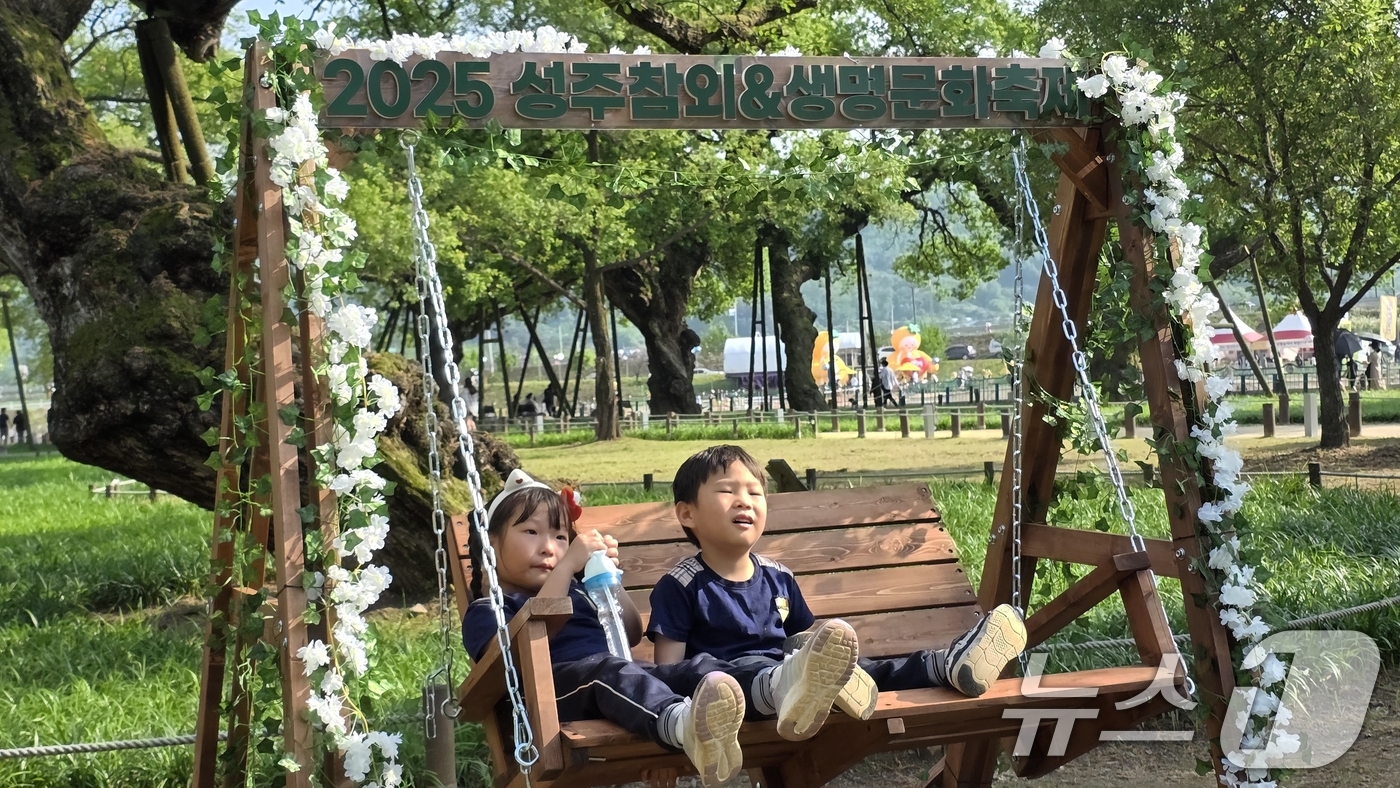 (성주=뉴스1) 정우용 기자 = 주말인 17일 경북 성주 성밖숲 일원에서 열리고 있는 '성주 참외·생명 문화축제'에 참여한 어린이들이 힐링포레스트 존에 설치된  나누그네를 타며 즐 …