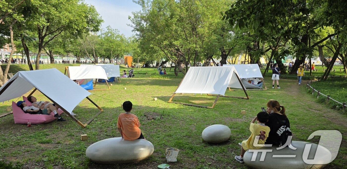 본문 이미지 - 주말인 17일 경북 성주 성밖숲 일원에서 열리고 있는 &#39;성주 참외·생명 문화축제&#39;에 참여한 가족들이 힐링포레스트 존에 설치된 힐링 스팟에서 휴식을 취하고 있다. 축제는 오는 18일까지 열린다. 2025.5.17/뉴스1 ⓒ News1 정우용 기자