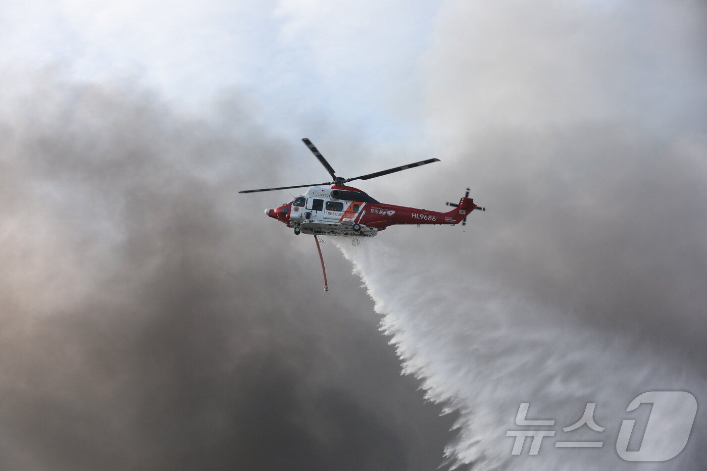 본문 이미지 - 금호타이어 광주공장 화재 발생 이틀쨰인 18일 오전 소방 헬기가 검은 연기를 뚫고 화재 현장에 물을 뿌리고 있다. 2025.5.18/뉴스1 ⓒ News1 최성국 기자