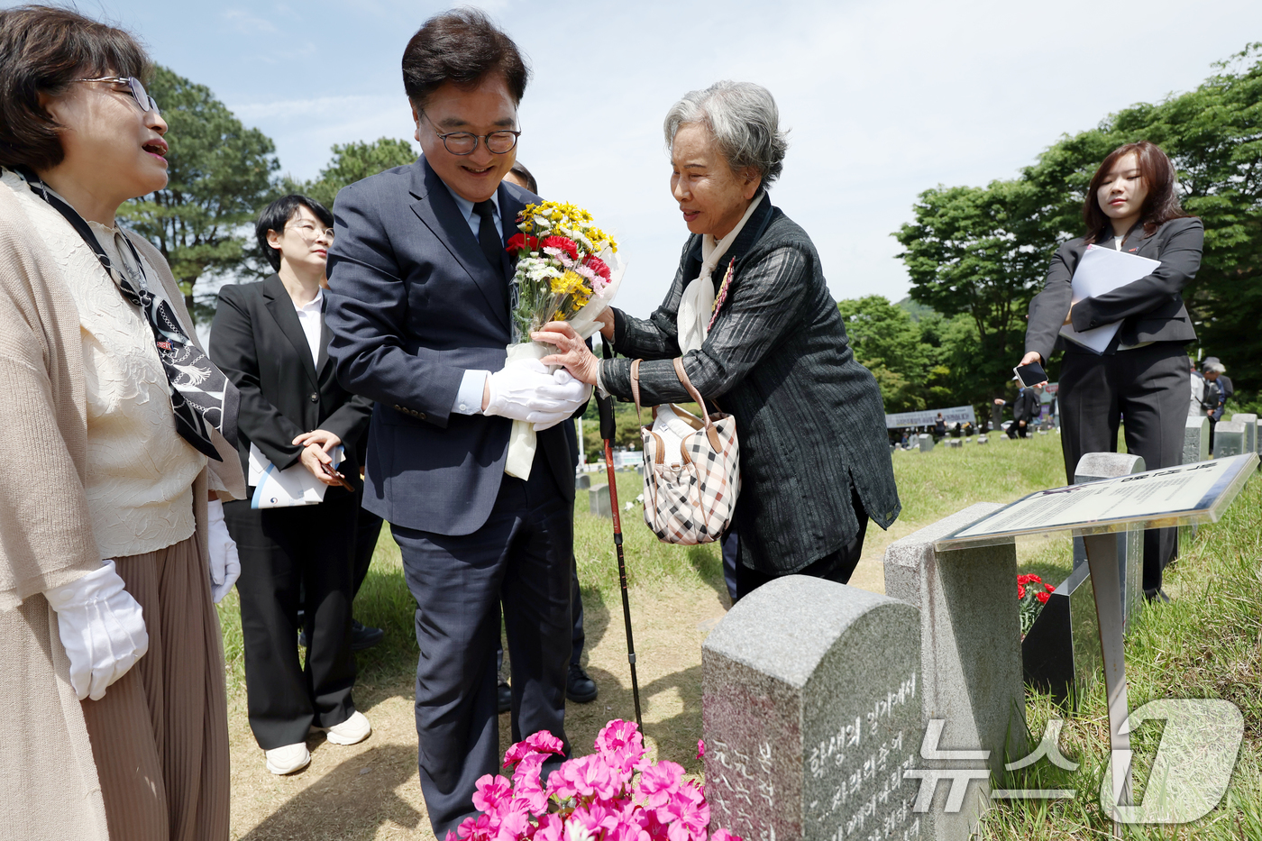 (광주=뉴스1) 이승현 기자 = 우원식 국회의장이 제45주년 5·18민주화운동 기념일인 18일 오전 광주 북구 망월동 민족민주열사묘역(구묘역)에서 열사 어머니에게 꽃다발을 받고 있 …