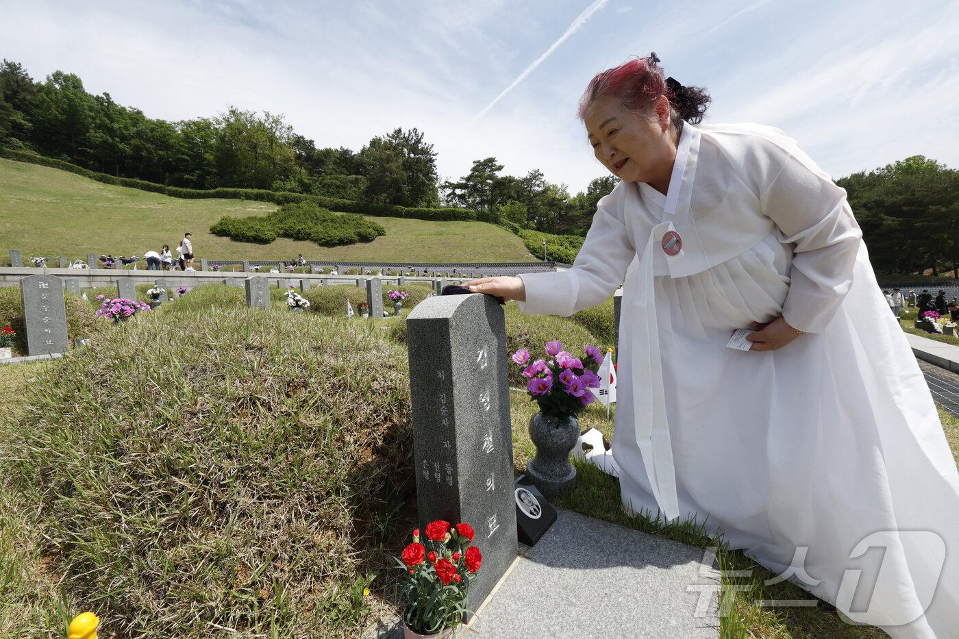 본문 이미지 - 18일 광주 북구 운정동 국립 5·18민주묘지에서 열린 제45주년 5·18민주화운동 기념식 후 김영철 열사의 아내 김순자씨가 묘비를 살피고 있다.2025.5.18/뉴스1 ⓒ News1 김태성 기자