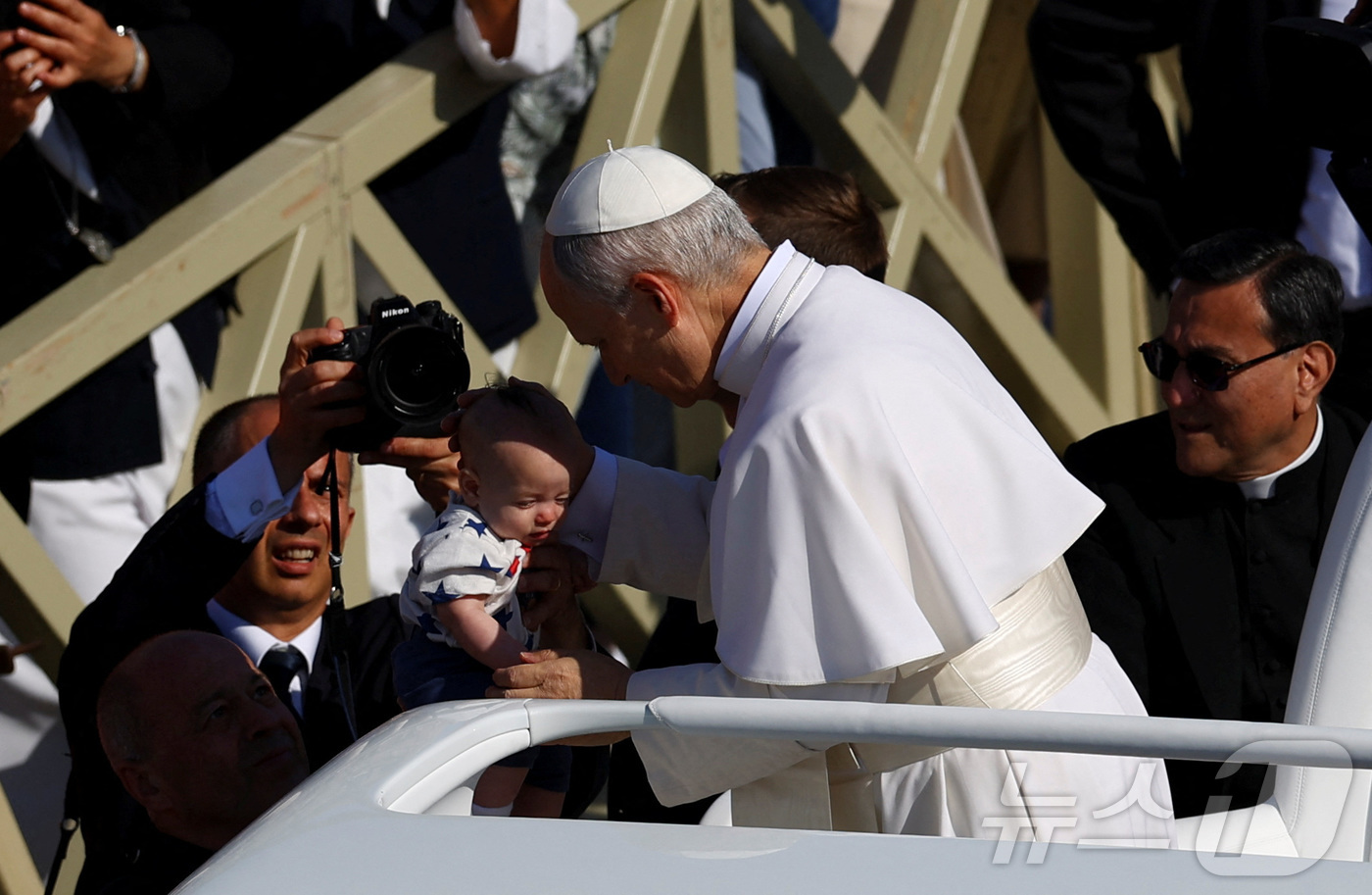 (로이터=뉴스1) 신기림 기자 = 교황 레오 14세가 즉위 미사를 위해 포프모빌(교황 전용차량)을 타고 바티칸 성베드로 광장에서 도착하면서 한 아기를 축복하고 있다. 2025.5. …