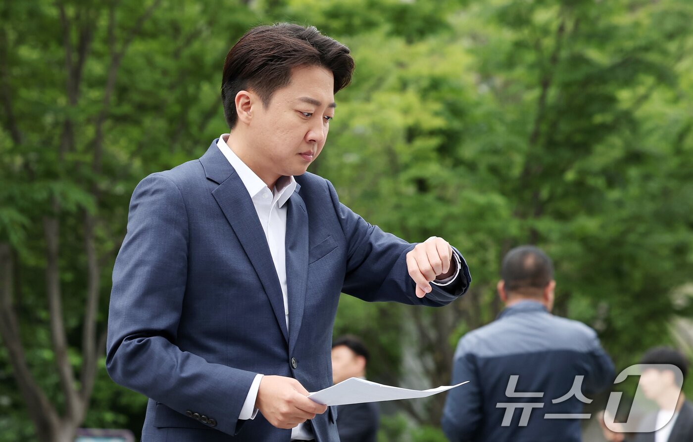 본문 이미지 - 이준석 개혁신당 대통령 후보가 19일 오전 서울 종로구 광화문광장 이순신 동상 앞에서 열린 기자회견에 참석하며 시계를 바라보고 있다. 2025.5.19/뉴스1 ⓒ News1 김성진 기자