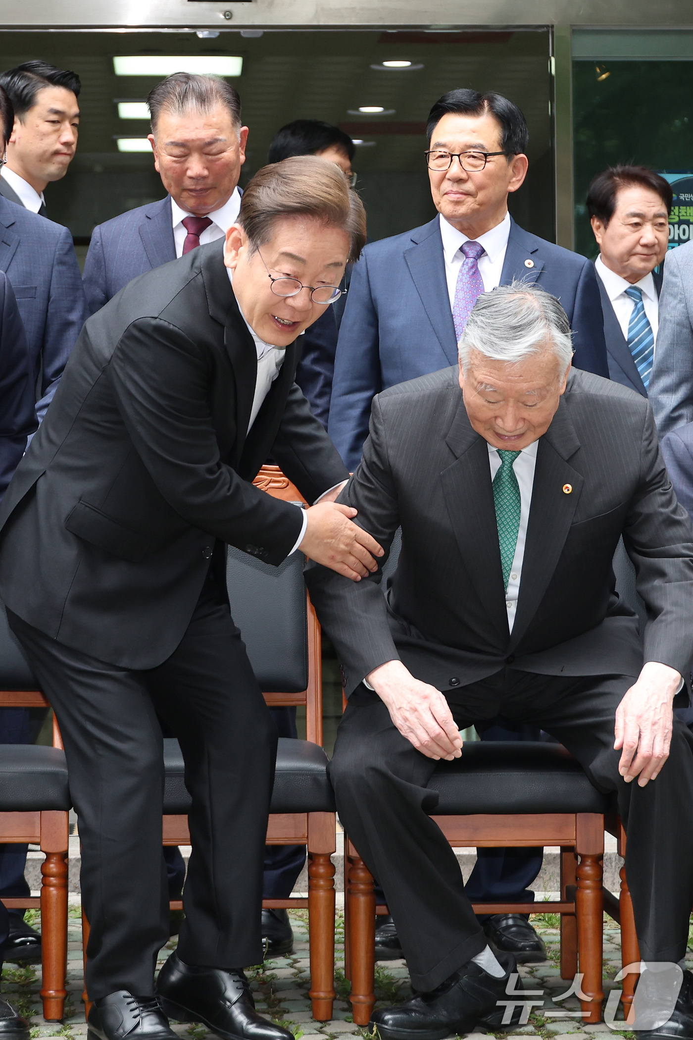 (서울=뉴스1) 안은나 기자 = 이재명 더불어민주당 대통령 후보가 19일 서울 용산구 대한노인회관을 방문, 기념촬영 자리에 앉는 이중근 회장을 부축하고 있다. (공동취재) 2025 …